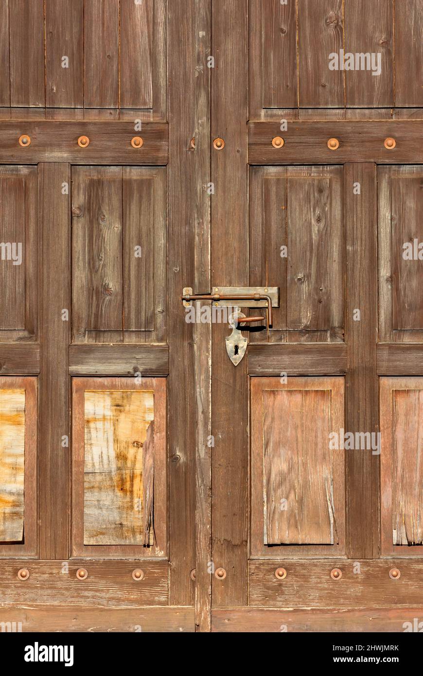 Vecchia porta esterna chiusa in legno con grande serratura Foto