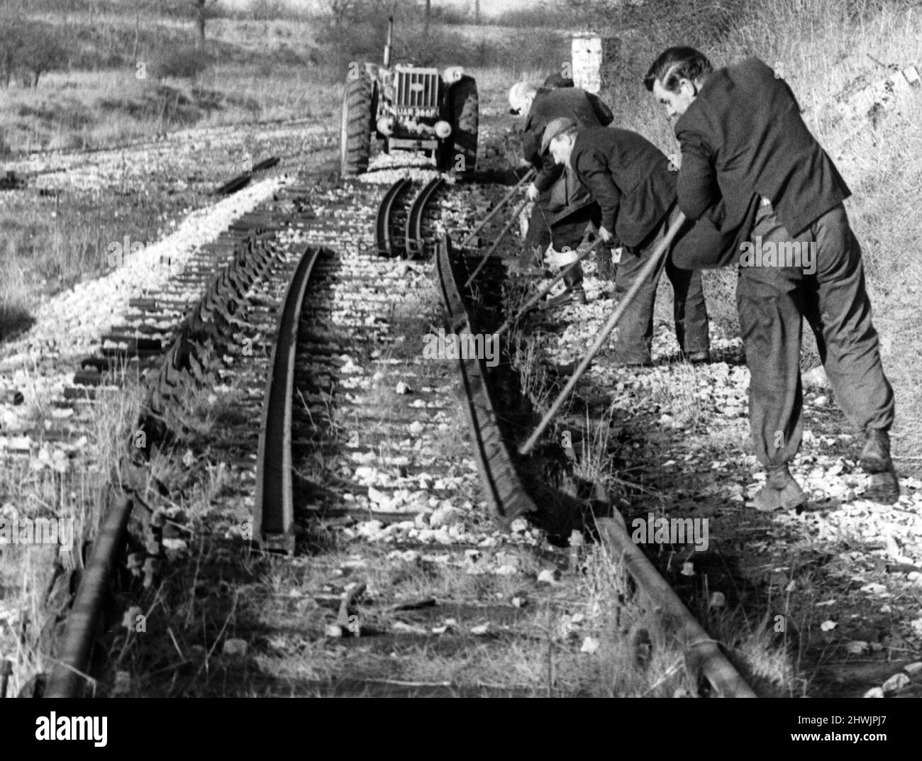 I lavoratori delle ferrovie britanniche leva una lunghezza di rotaia dalle sue sedie sulla vecchia linea Nuneaton-Ashby a Weddington, Nuneaton. 14th gennaio 1972. Foto Stock