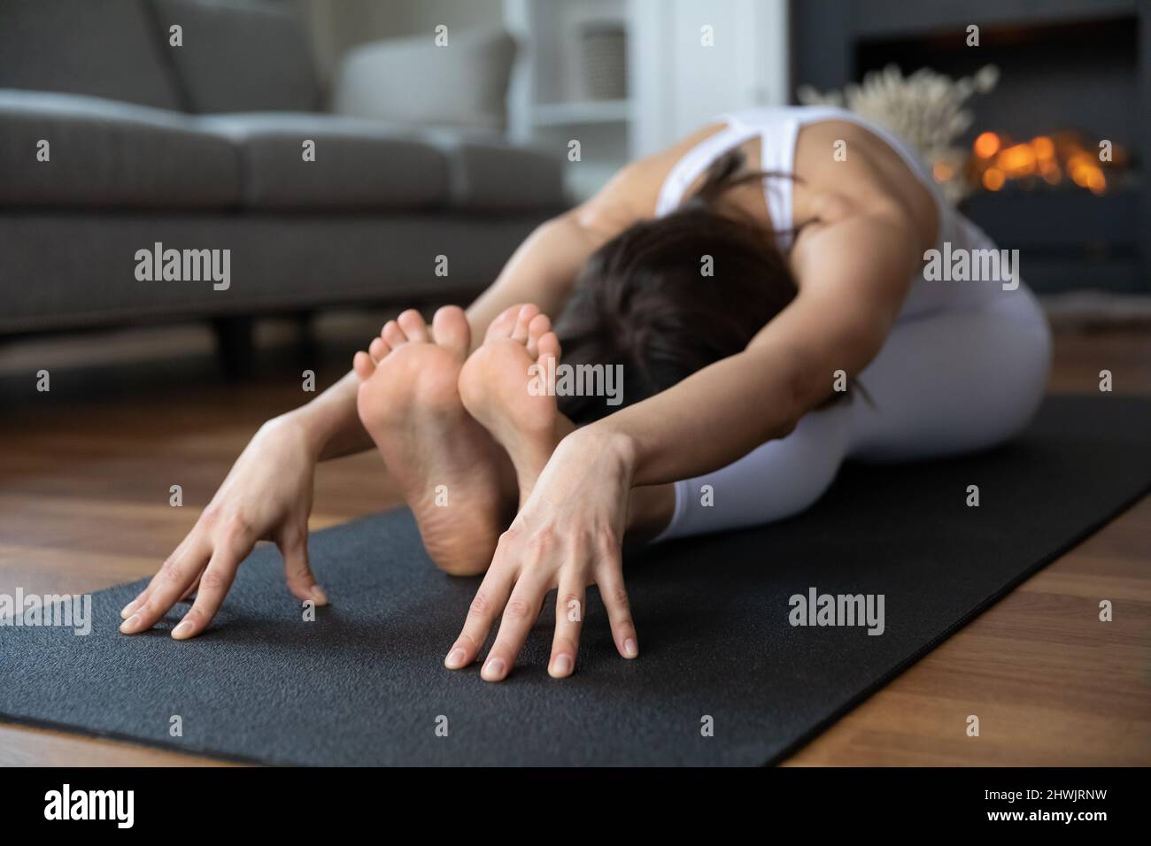 Giovane donna seduta in seduta Forward Bend yoga asana Foto Stock