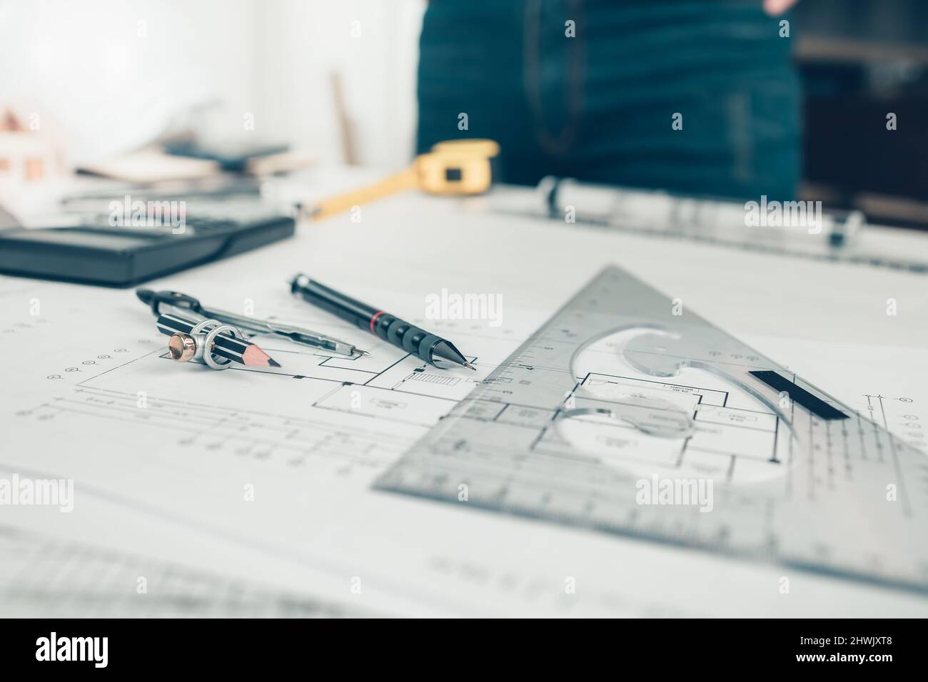 Architetto ingegnere utilizzare penna, righello angolare triangolare e bussola sul disegno lavorando su bueprint. Progettazione e costruzione di case. Foto Stock