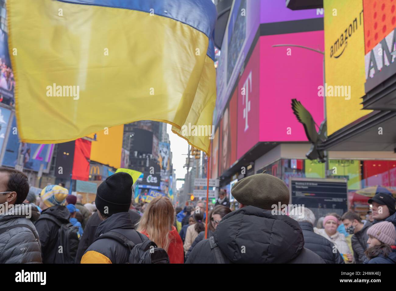 NEW YORK, N.Y. – 5 marzo 2022: Una persona detiene una bandiera Ucraina a Times Square durante una protesta contro l’invasione dell’Ucraina da parte della Russia. Foto Stock