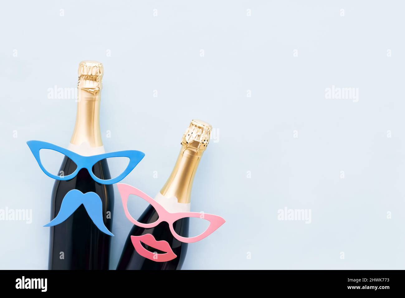 Sfondo delle vacanze con oggetti di festa, maschere e champagne su uno sfondo azzurro chiaro. Concetto di Carnevale, sfondo purim. Vista dall'alto, spazio di copia Foto Stock