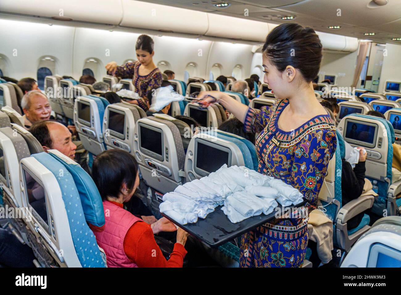 San Francisco California, Aeroporto Internazionale, partenza da Singapore Airlines, donne asiatiche frequentanti servizio passeggeri che offrono asciugamano caldo Foto Stock