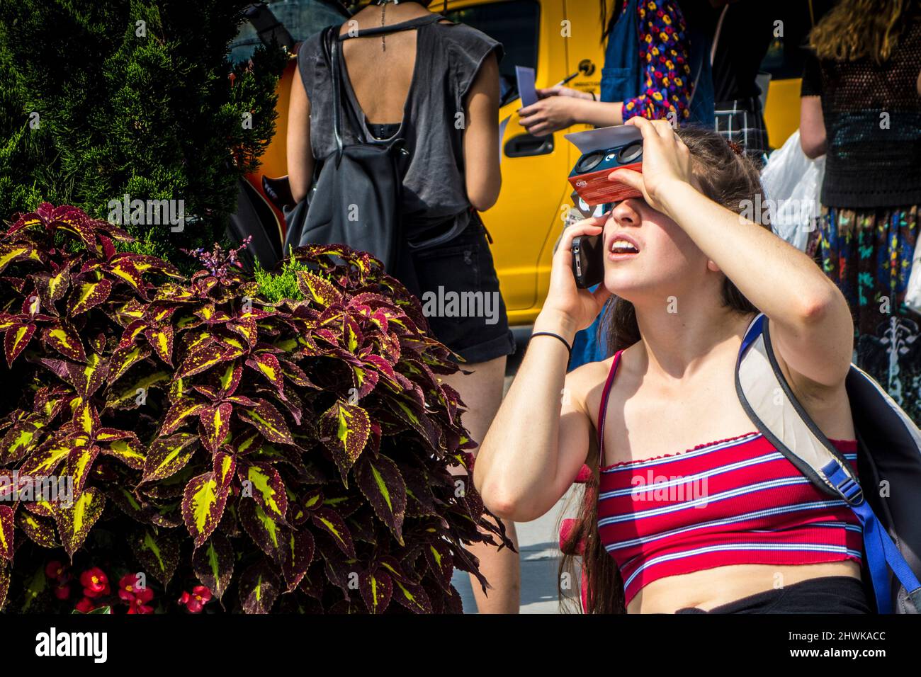 Donna che indossa occhiali speciali per vedere una parziale eclissi del sole nel mese di agosto 2017, New York City, Stati Uniti Foto Stock