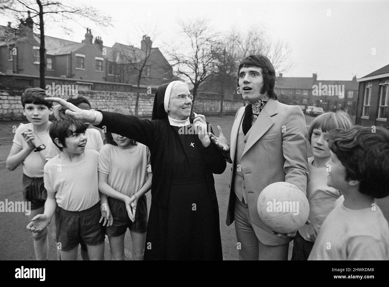 Kevin Keegan, l'idolo calcistico inglese e Liverpool, torna alla sua vecchia scuola, la scuola elementare di San Francesco Saverio a Doncaster, dove incontra la sua direttrice, Suor Mary Oliver. Suor Mary scrisse sulla sua relazione scolastica anni fa 'bravo sportivo. Kevin deve essere incoraggiato con il suo calcio'. Nella foto, Suor Mary Oliver manda in modo scherzoso Kevin Keegan fuori - come Kevin stava dando alcuni consigli sul calcio ad alcuni della squadra di calcio della scuola - e guarda il volto sorpreso di Kevin mentre Suor Mary Oliver punta allo spogliatoio. 8th gennaio 1973. Foto Stock