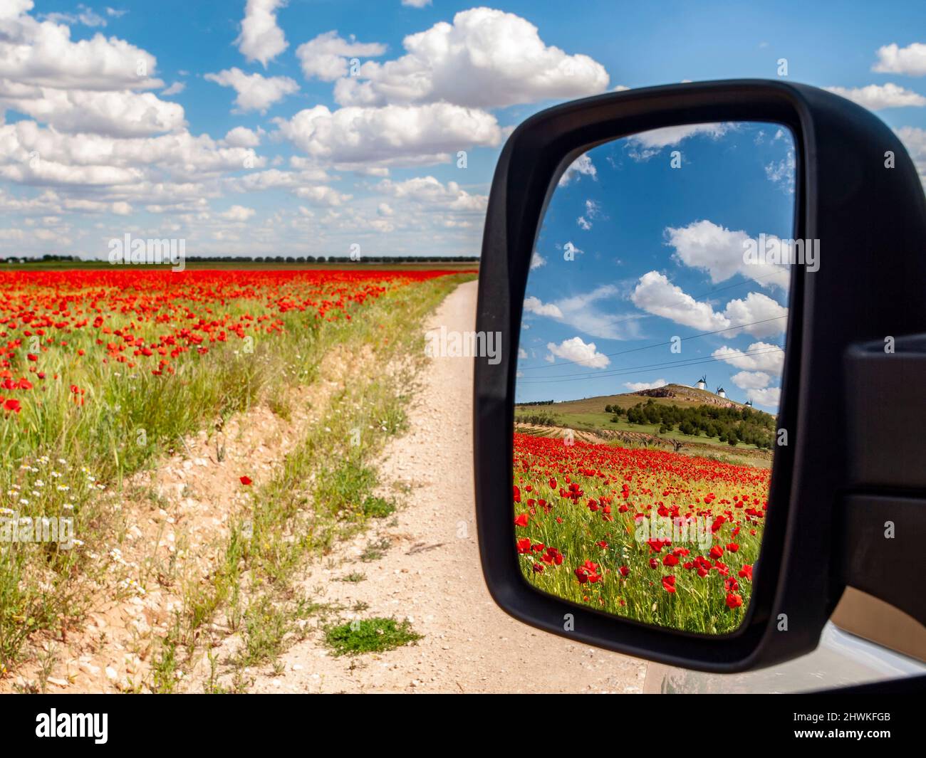 Paesaggio primaverile con i mulini a vento di la Mancha sullo sfondo riflessi in uno specchio retrovisore auto a Ciudad Real Foto Stock