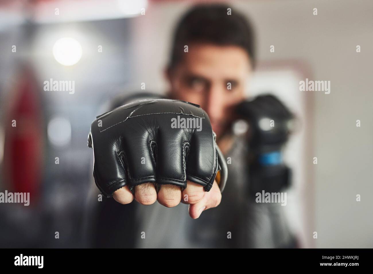 Venendo a voi forza piena. Ritratto corto di un professionista di addestramento del combattente nella palestra. Foto Stock