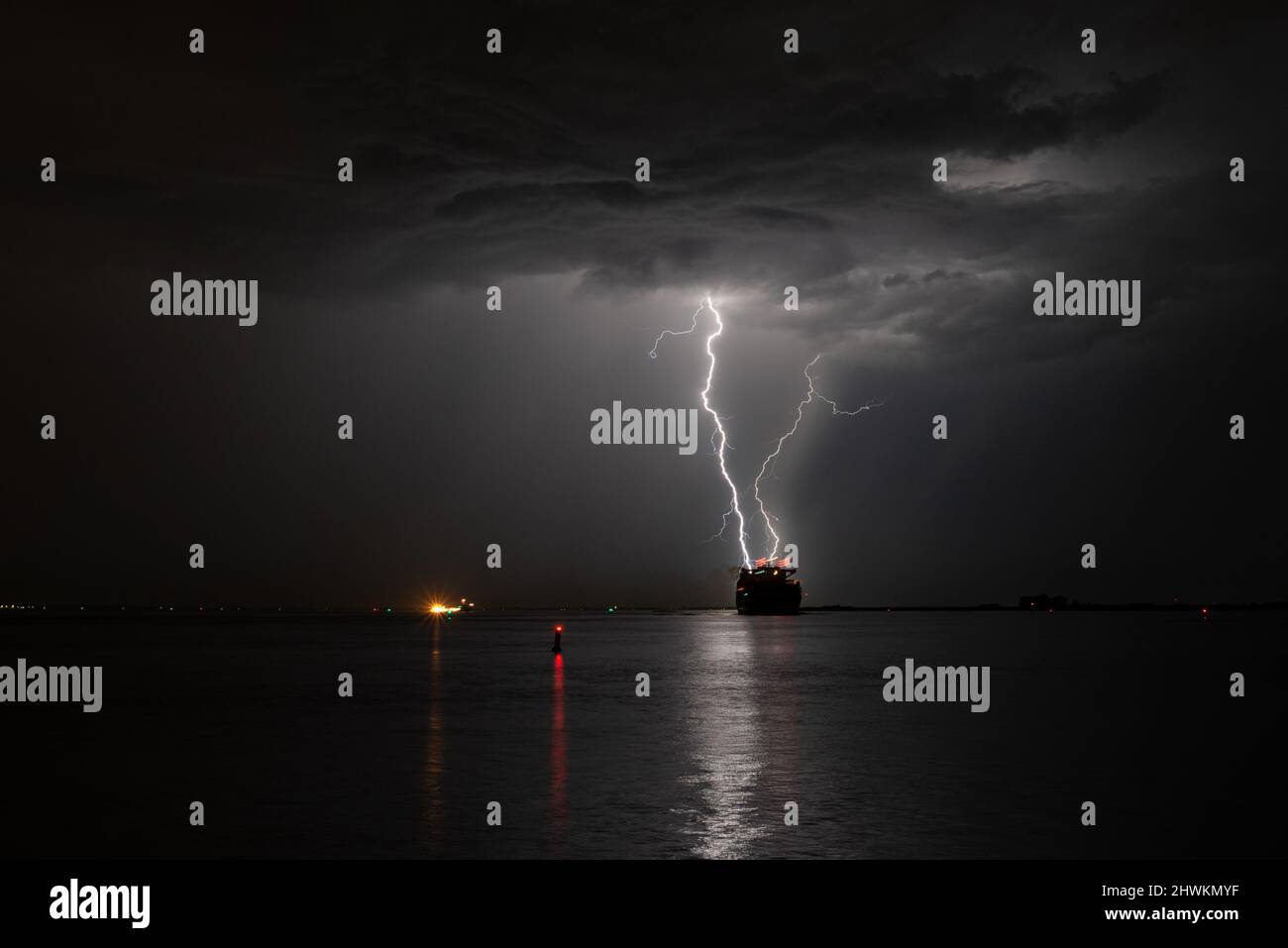 Fulmini colpisce in mare vicino a una nave Foto Stock