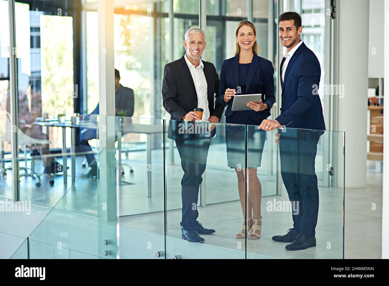 Il successo è tutto in un lavoro di giorni per loro. Ritratto di tre colleghi in piedi insieme in un ufficio moderno. Foto Stock