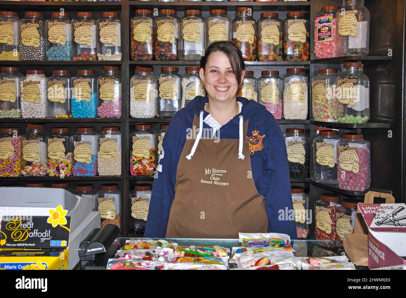 Giovane donna assistente in un negozio di pasticceria, Nantwich, Cheshire, Inghilterra, Regno Unito Foto Stock