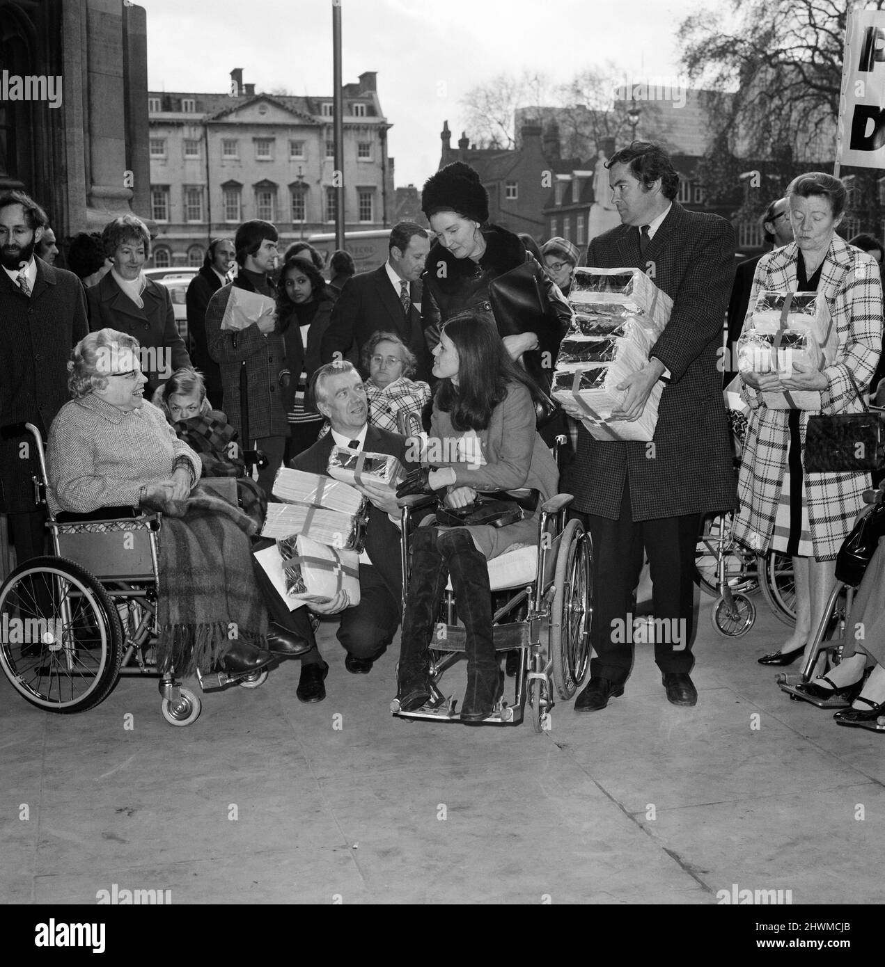 Disabili e ciechi uomini e donne fanno una petizione alla Camera dei Comuni chiedendo una migliore retribuzione per i disabili. La petizione, organizzata dal DIG (Disablement Income Group) è stata consegnata a MP's, incluso Jack Ashley di Stoke su Trent South. Nella foto, Jack Ashley, MP Center, con Rosalie Wilkins (in sedia a rotelle). 14th novembre 1972. Foto Stock