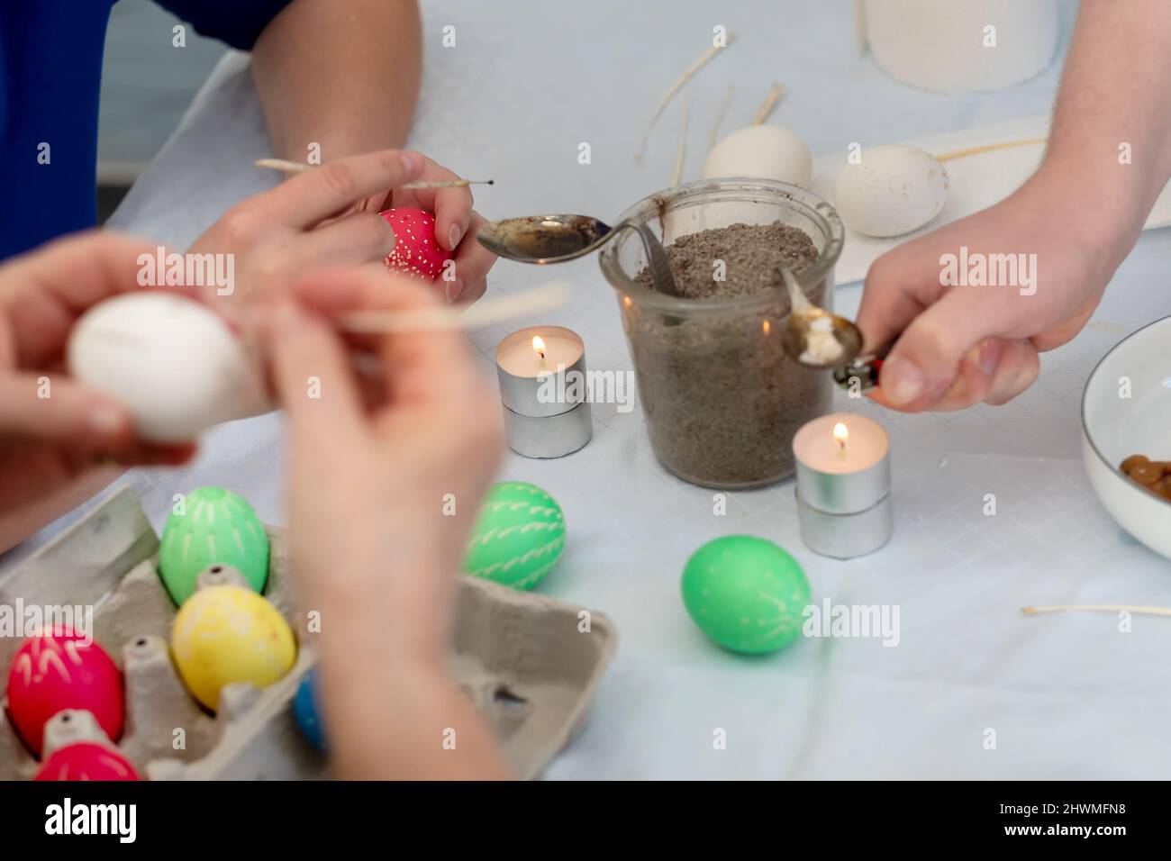 Molte mani femminili dipinge le uova di Pasqua colorate secondo la tradizione tedesca Sorbian con un quillo di oca rifinito, teste dell'ago e candela di api fusa wa Foto Stock