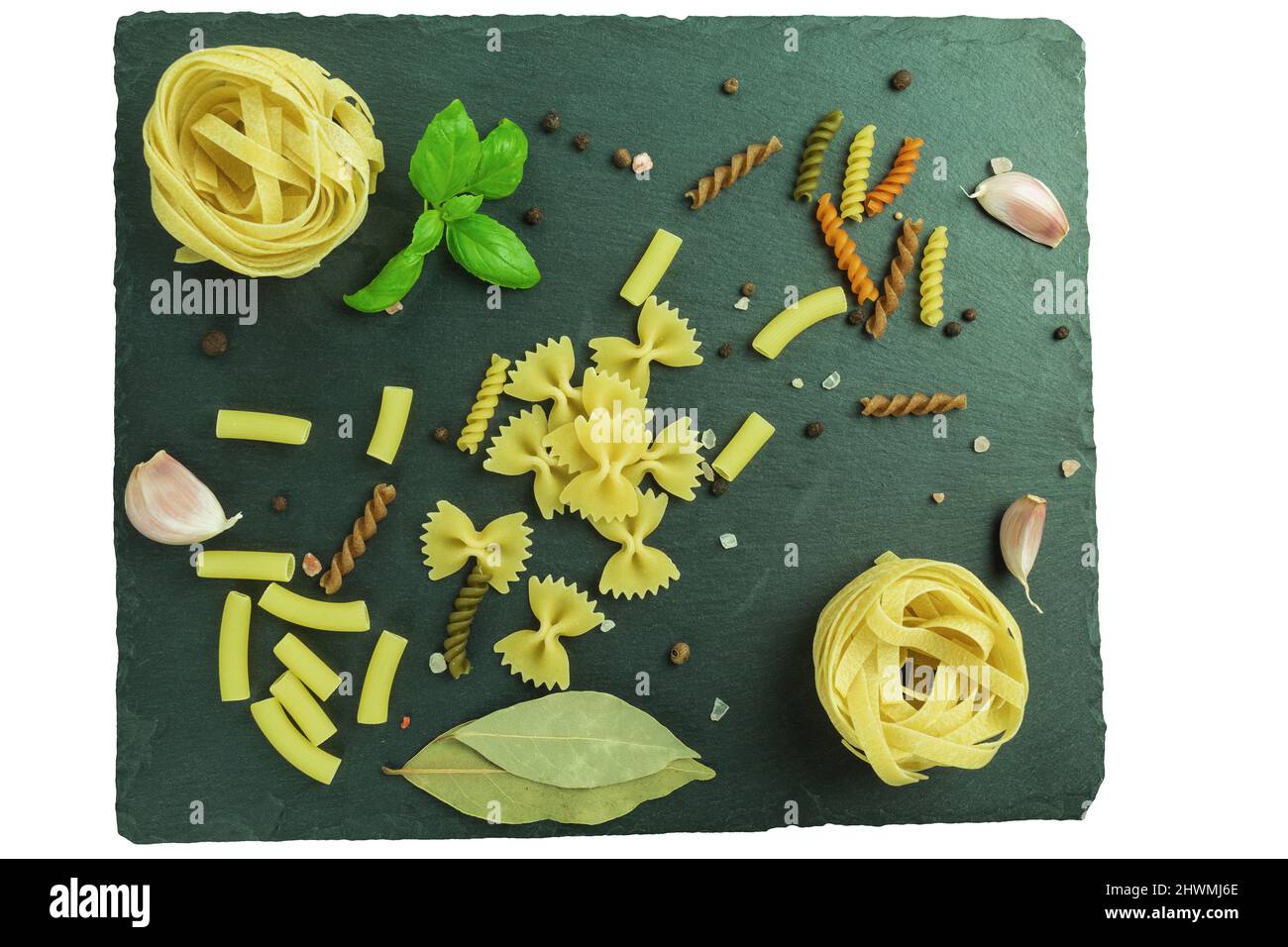 Pasta cruda di vario tipo e spezie su tavola di legno. Vista dall'alto. Macaron su tavola di legno, spazio per il testo Foto Stock