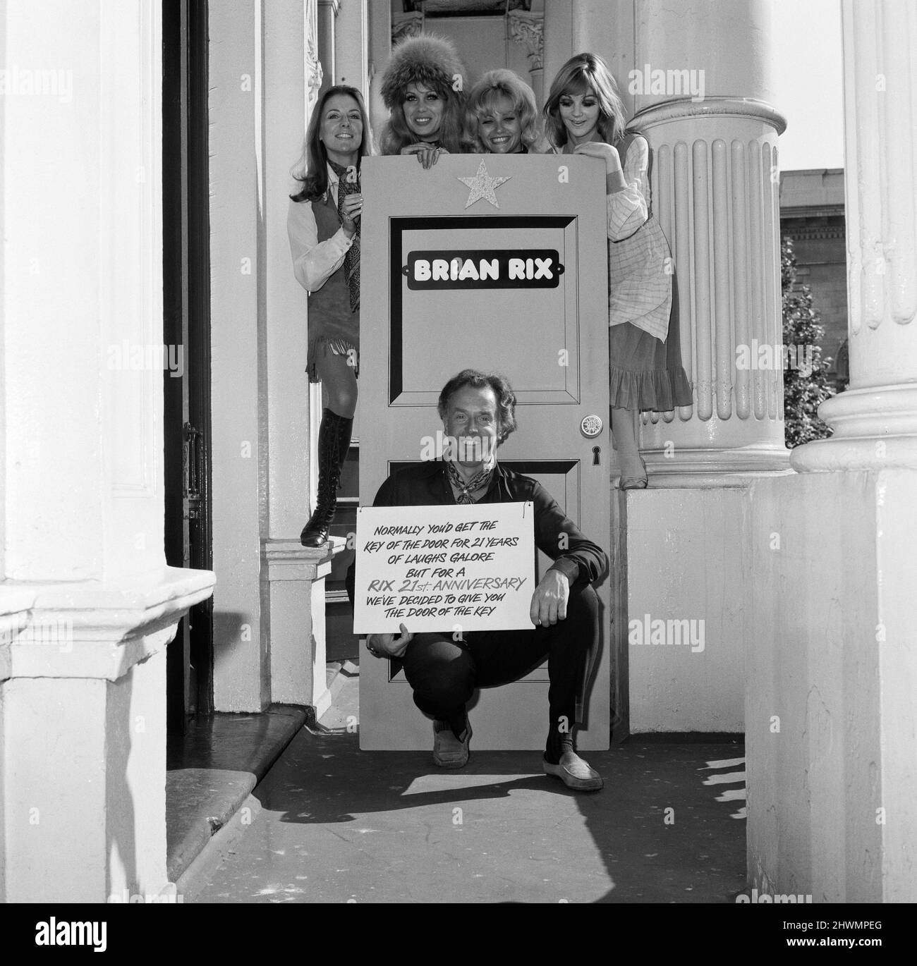Brian Rix festeggia 21 anni di farsa, perché non fu la sua data nel 1950 che il suo gioco 'riluttanti Eroi' aprì a Londra. Oggi sta provando per il suo prossimo show "non solo mentire lì, dire qualcosa!" Che apre al Garrick Theatre il 15th settembre. Quando è arrivato oggi, quattro delle ragazze della mostra gli hanno presentato una gigantesca tessera di compleanno a forma di porta. Dietro Brian Rix ci sono L-R Deborah Grant, Joanna Lumley, Donna Reading e Nina Thomas. 12th settembre 1971. Foto Stock