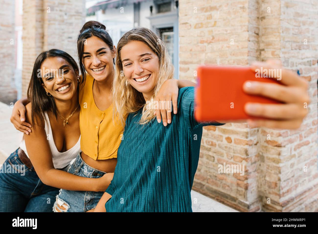 Tre giovani amici multirazziale che si divertono a prendere autoritratto con il telefono cellulare Foto Stock