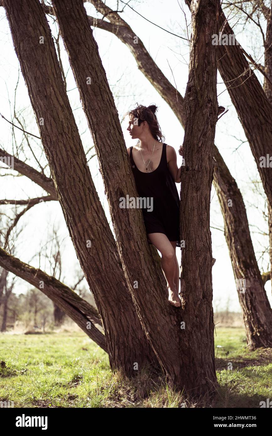 sana donna naturale guarda nel sole in piedi albero a piedi nudi Foto Stock
