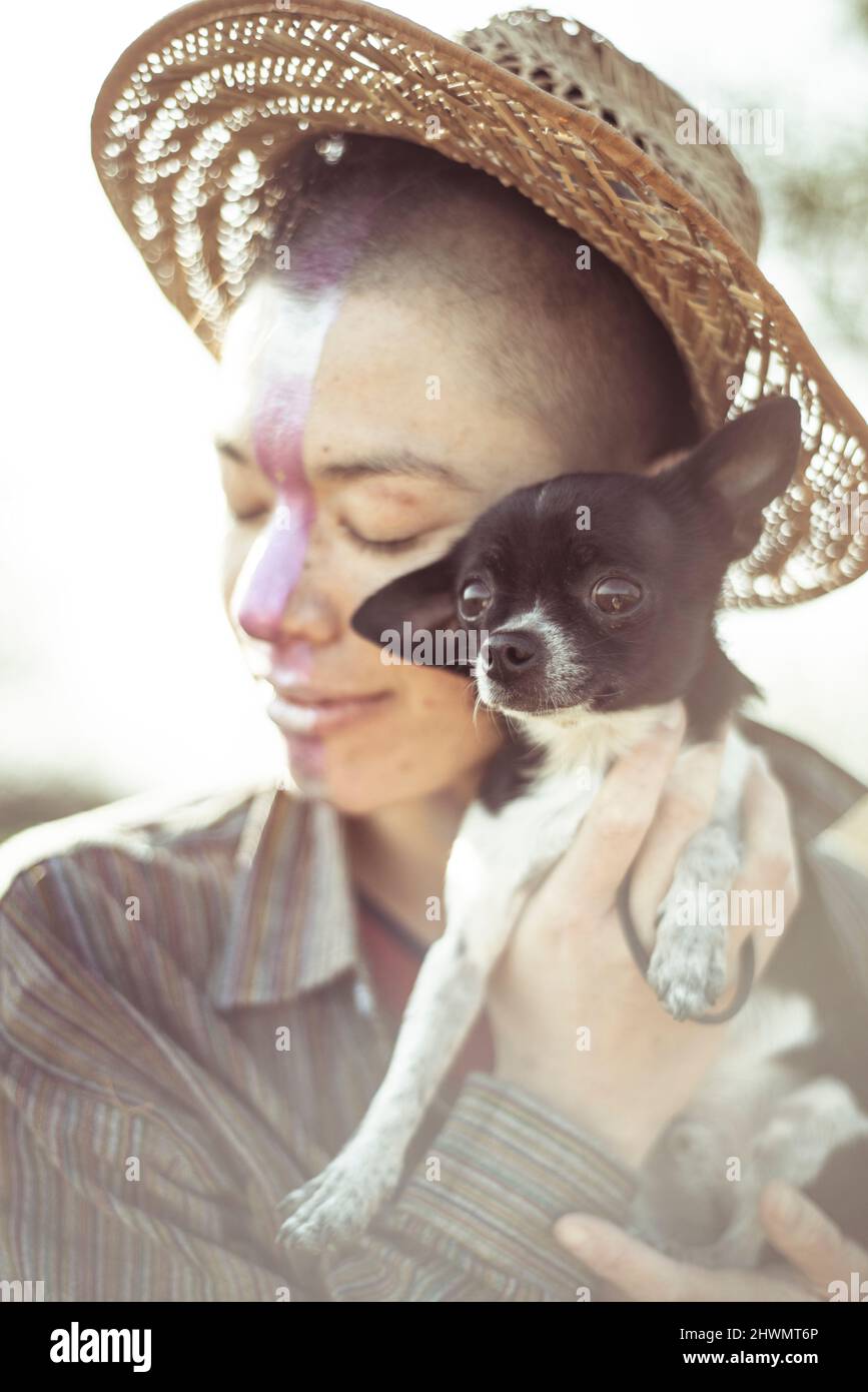Carino chihuahua cane hugging persona alternativa in cappello e facepaint Foto Stock