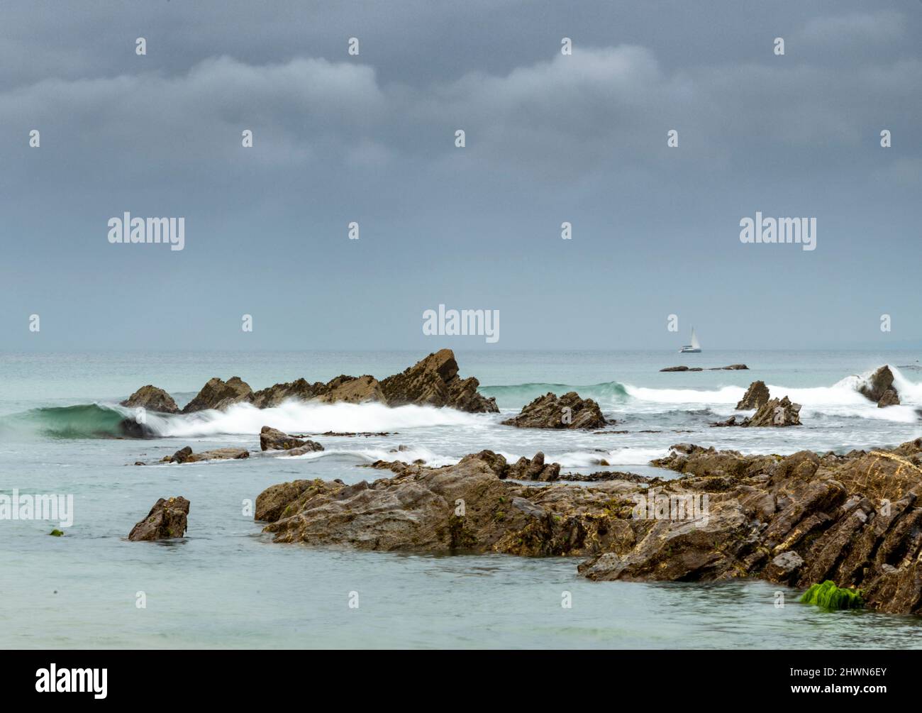 Passando la barca si dirige verso le rocce, suggerendo pericolo al mare, vicino alla Penisola Lizard, Dollar Cove prende il nome dai dollari d'argento trovati qui da un anc Foto Stock