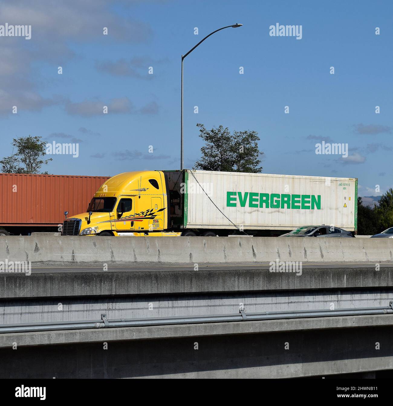 Camion che trasporta un contenitore di spedizione Evergreen sulla superstrada 880 a Union City, California Foto Stock