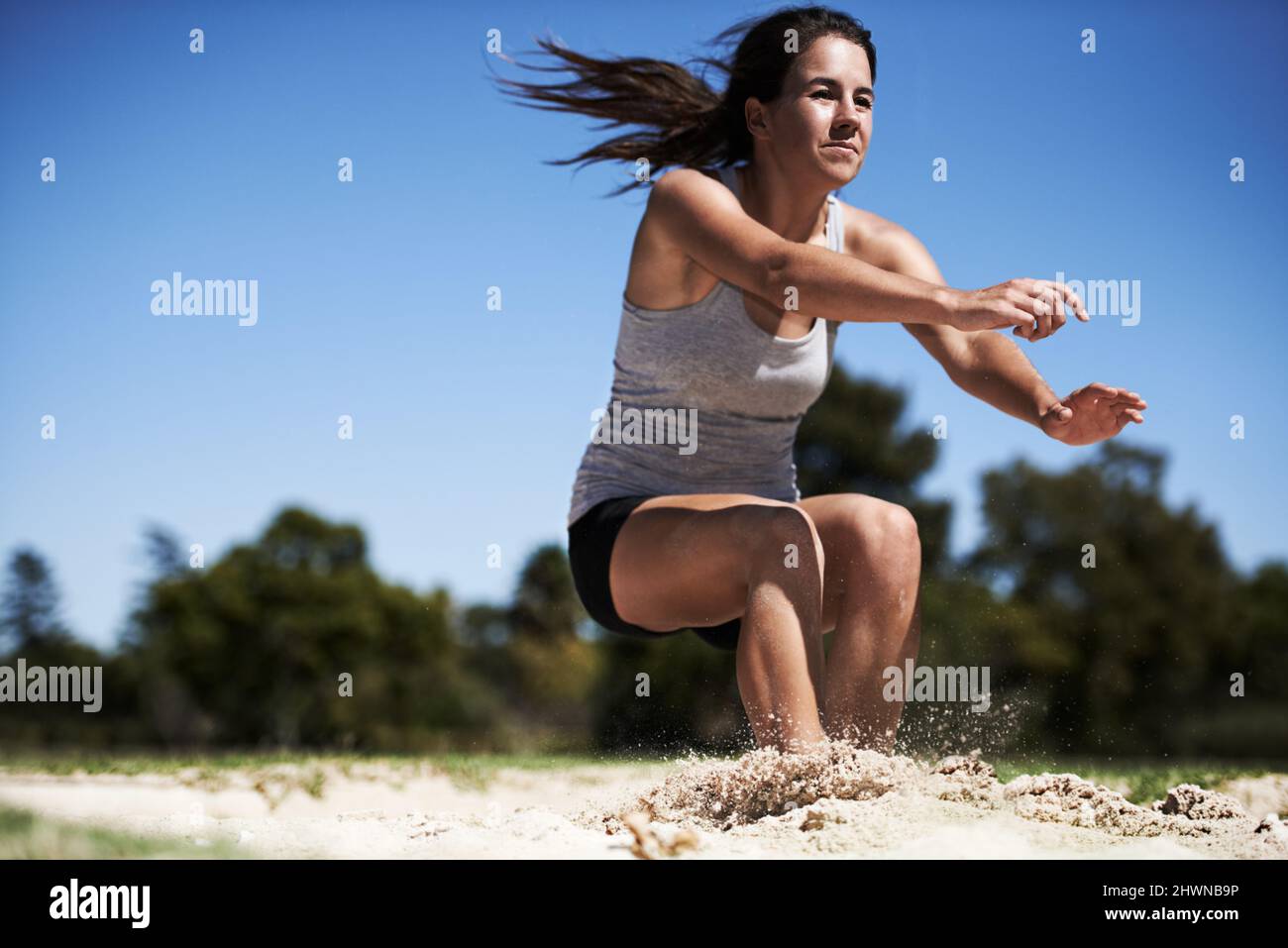 Andando il più lontano possibile. Una giovane donna che fa un salto lungo. Foto Stock