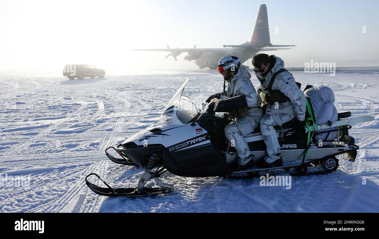 Berets verdi dell'esercito degli Stati Uniti assegnati a 10th gruppo speciale delle forze (Airborne), USA una motoslitta per uscire dal tarmac dopo aver caricato l'attrezzatura su un US Air Force C-130 Hercules con il 731st Airlift Squadron per il movimento a nord del Circolo polare Artico a sostegno dell'esercizio ARCTIC EDGE 2022 presso l'aeroporto internazionale di Fairbanks, Fairbanks, Alaska, 2 marzo 2022. AE22 è un esercizio del comando del Nord degli Stati Uniti (USNORTHCOM) programmato ogni due anni, che si svolge per la prima volta nel 2018. Gli esercizi artici sono stati condotti in Alaska per gli ultimi cinque decenni con nomi diversi come JACK FROST e BRUM FROST. (STATI UNITI Esercito Foto Stock