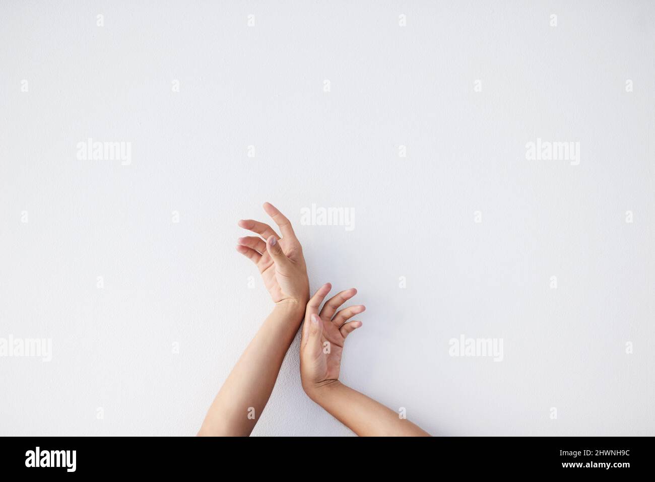 Le tue mani sono gli strumenti migliori. Un'immagine ritagliata di una persona irriconoscibile si estende su uno sfondo grigio. Foto Stock