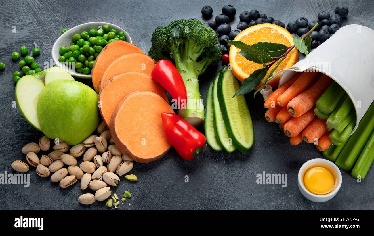 Alimenti alti in luteina su sfondo scuro. Cibo per occhi sani. Alto in antiossidanti, minerali e vitamine. Foto Stock