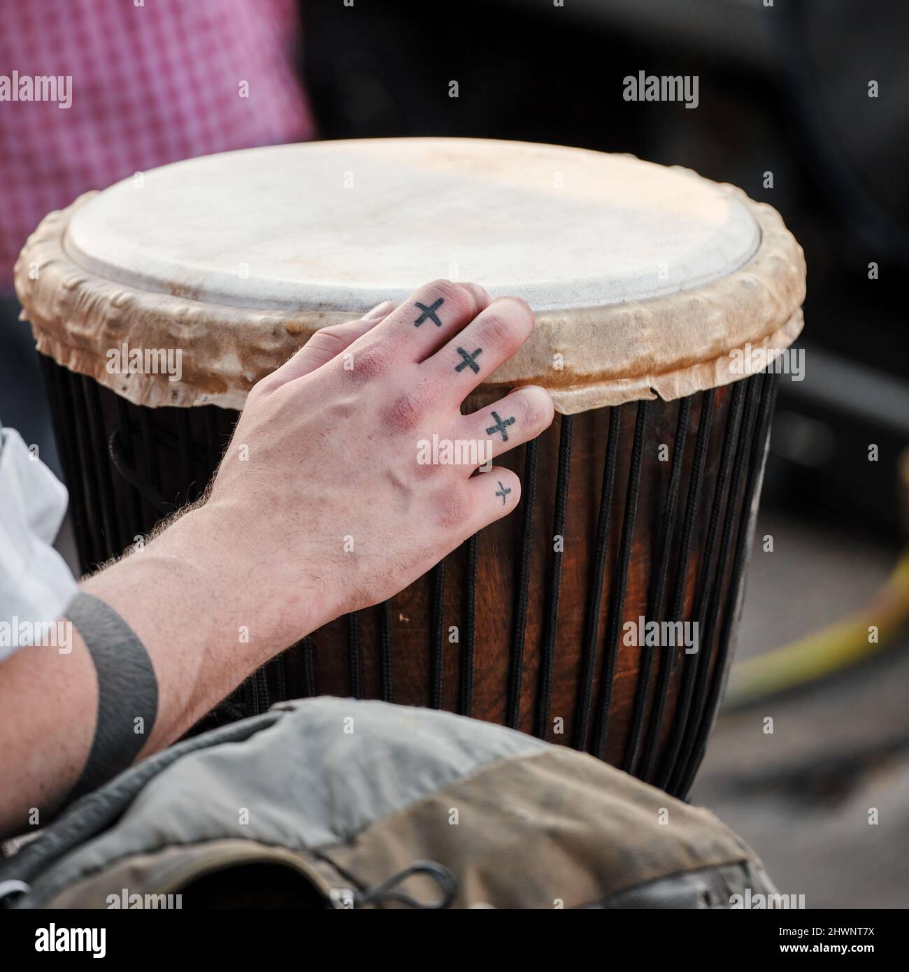 Mano maschile che suona uno strumento musicale africano djembe drum bongo. Foto Stock