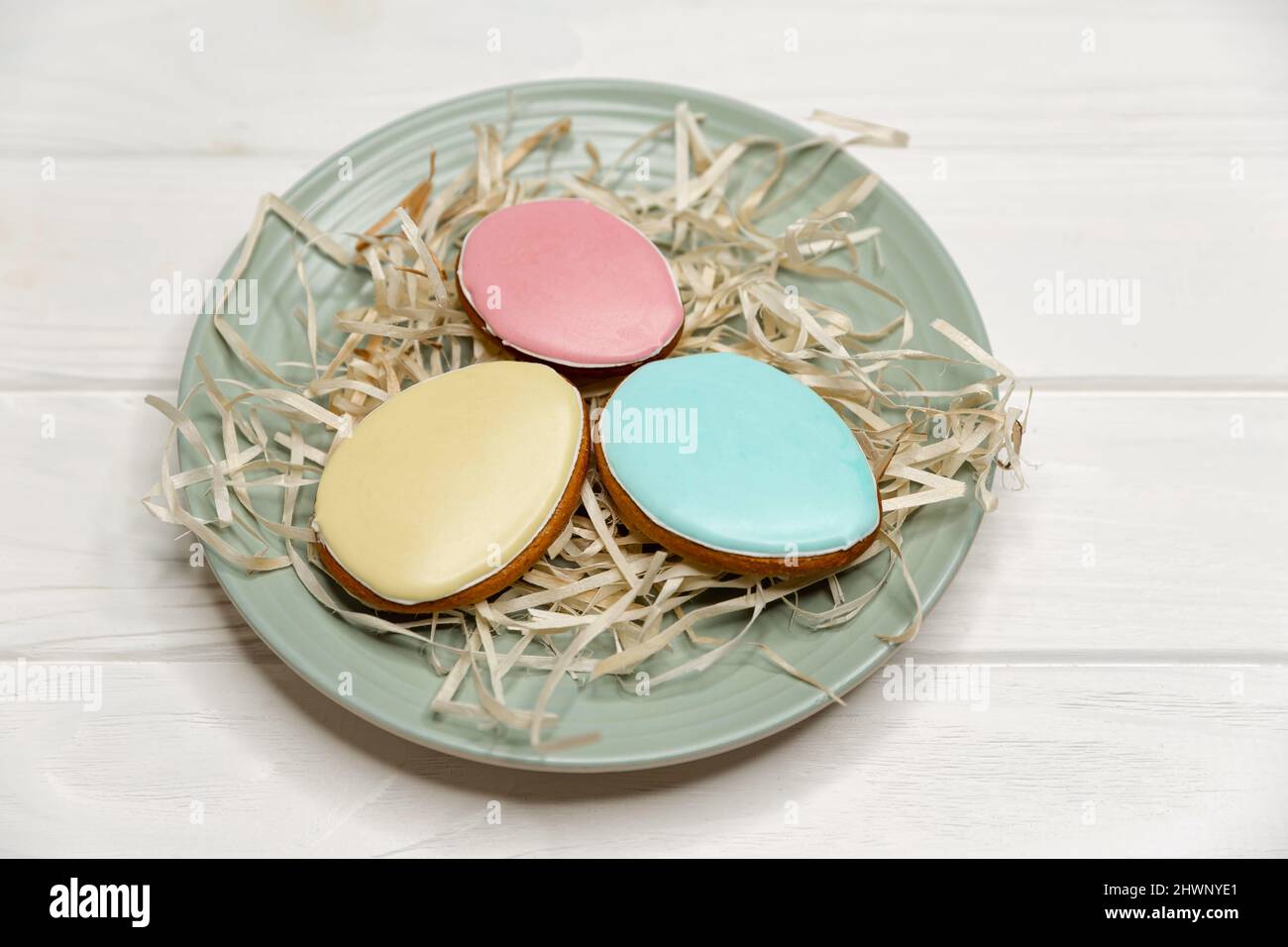 Deliziosi biscotti con smalto colorato su un piatto di legno bianco. Foto Stock