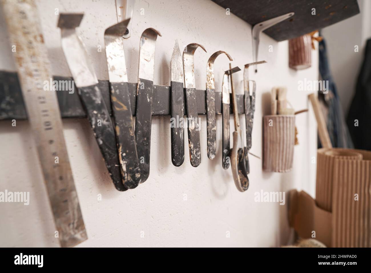 Barra porta attrezzi montata a parete con vari utensili per tornitura e fresatura argilla Foto Stock