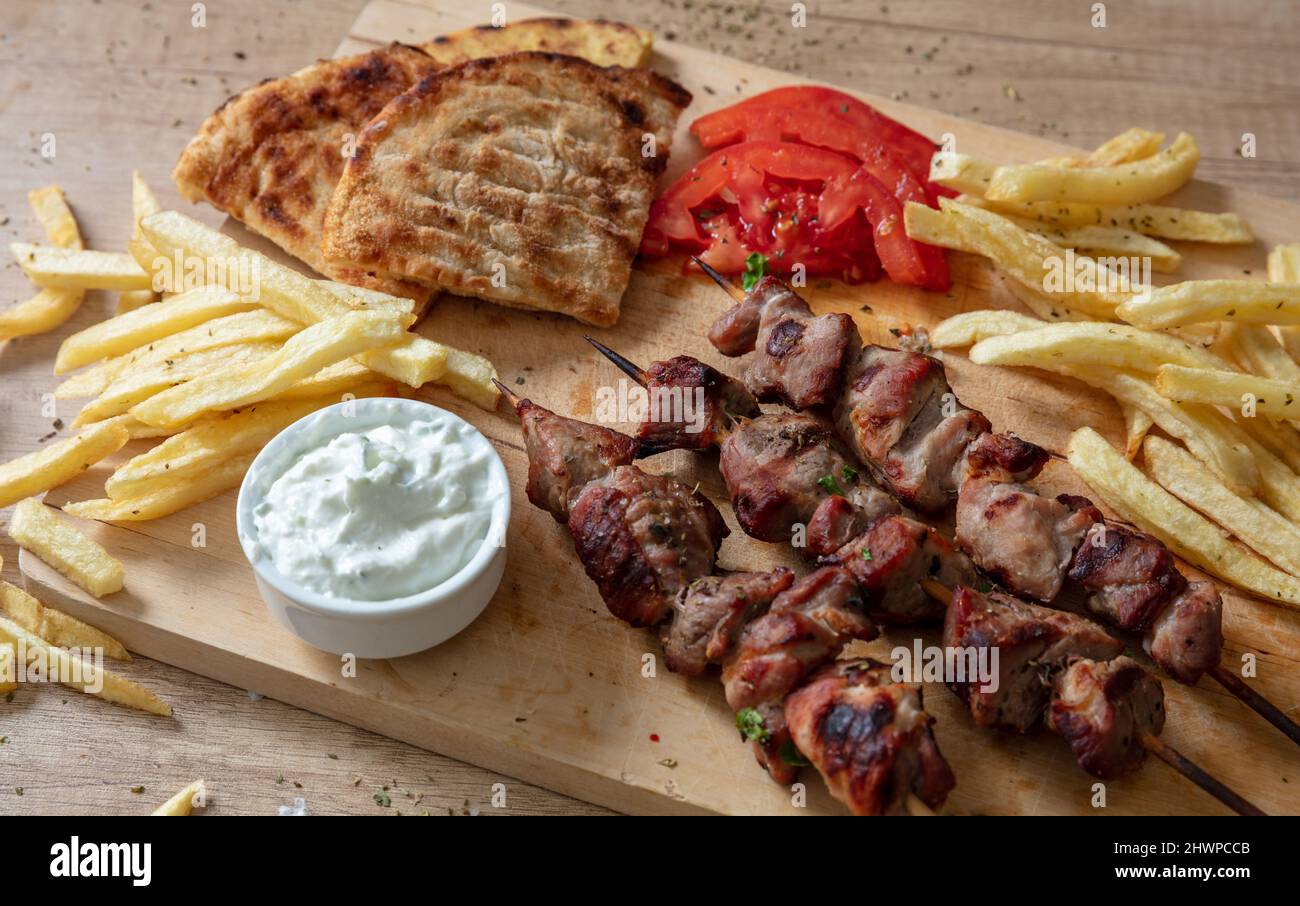 Piatto souvlaki, cibo di carne greca. Spiedini alla griglia e pita pane su tavola di legno, da vicino sopra vista, Foto Stock