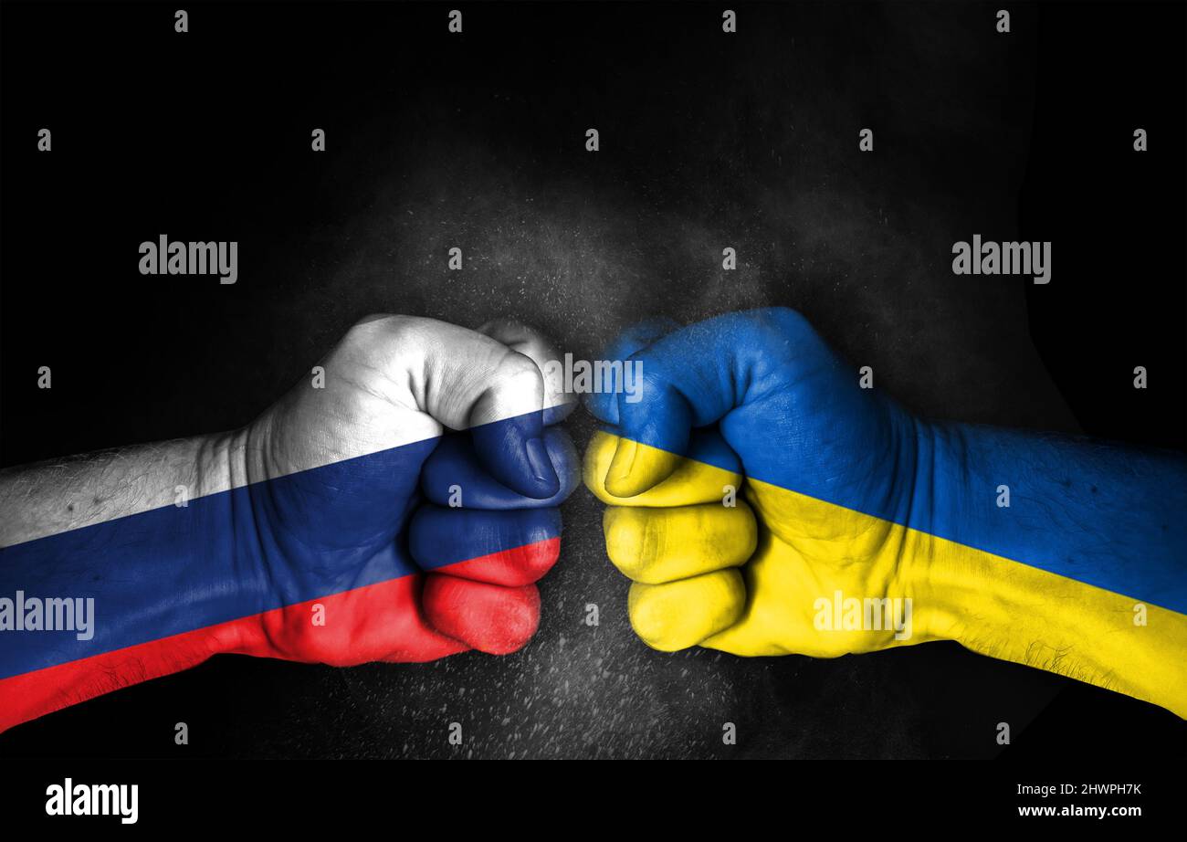 Crisi di guerra in Russia e Ucraina, fisti con bandiere dipinte, due paesi nemici che combattono l'uno con l'altro, concetto di conflitto isolato su sfondo nero, Foto Stock