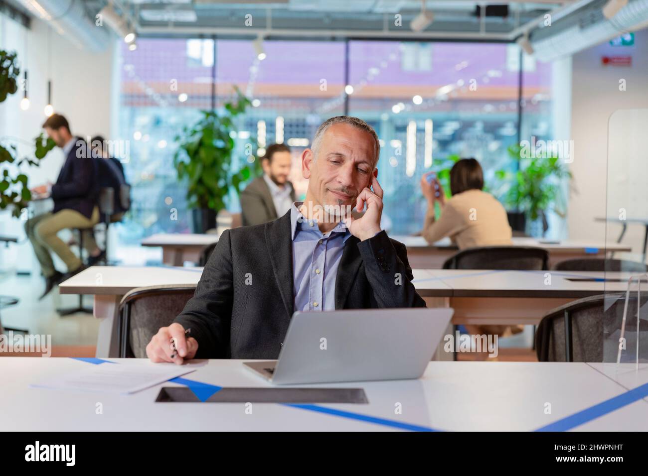 Uomo d'affari che lavora su un notebook in ufficio Foto Stock