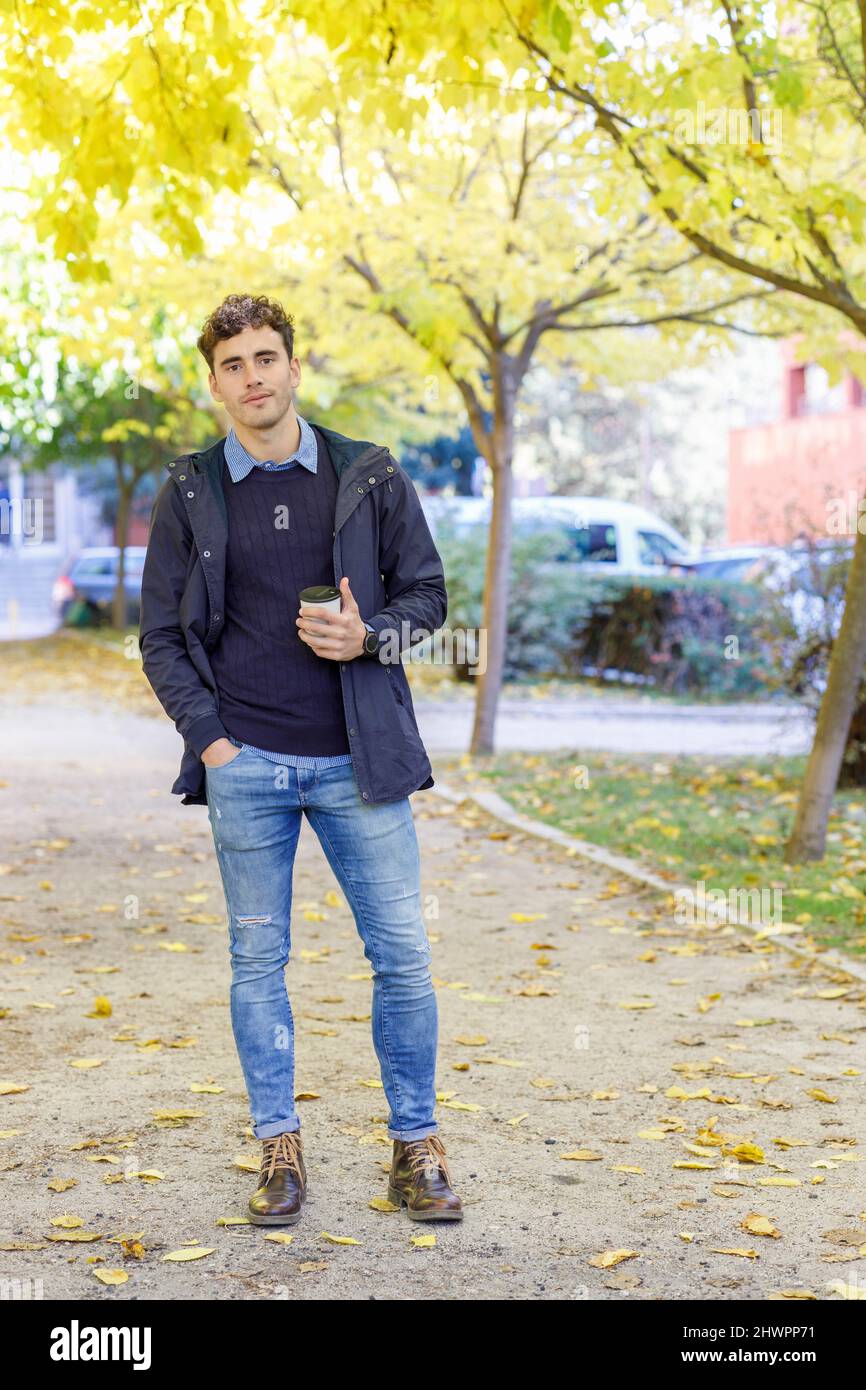 Giovane uomo con mano in tasca al college Park Foto Stock