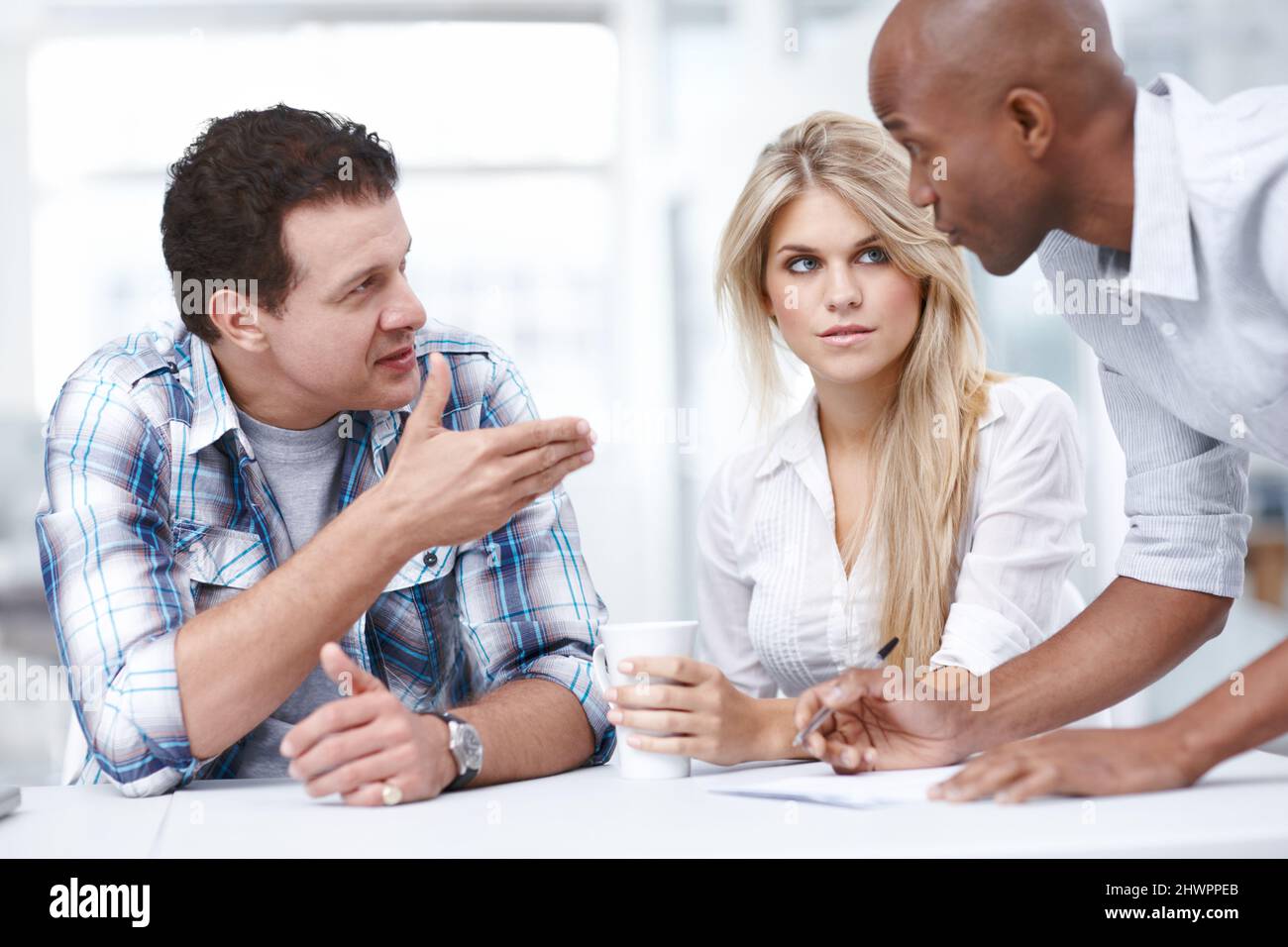 Egli dà sempre un buon consiglio. Tre professionisti del design che hanno una riunione. Foto Stock