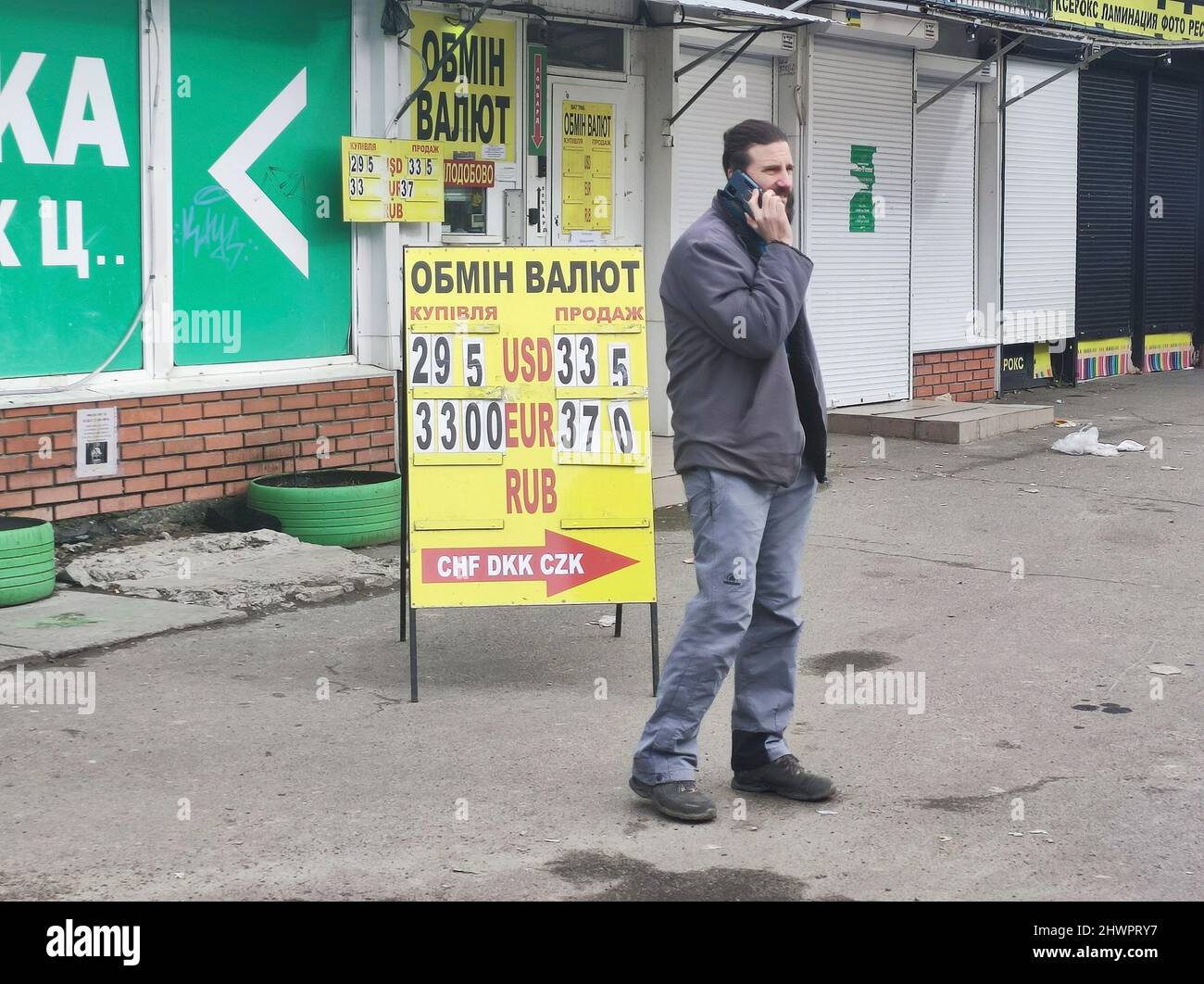 Non esclusiva: KIEV, UCRAINA - 06 MARZO 2022 - un uomo parla al telefono accanto a uno stand di cambio valuta, Kiev, capitale dell'Ucraina Foto Stock