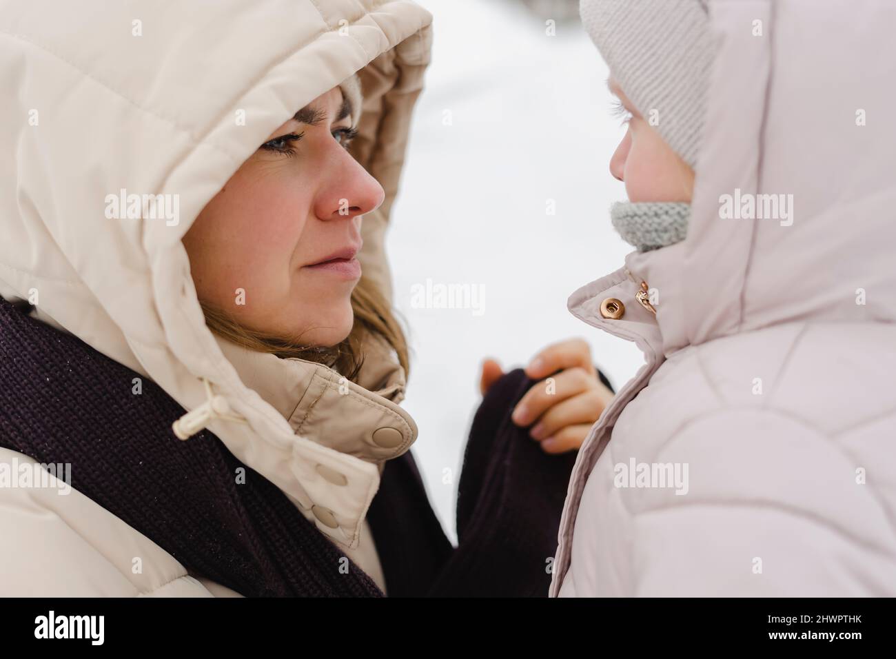 Madre che guarda la figlia in inverno Foto Stock
