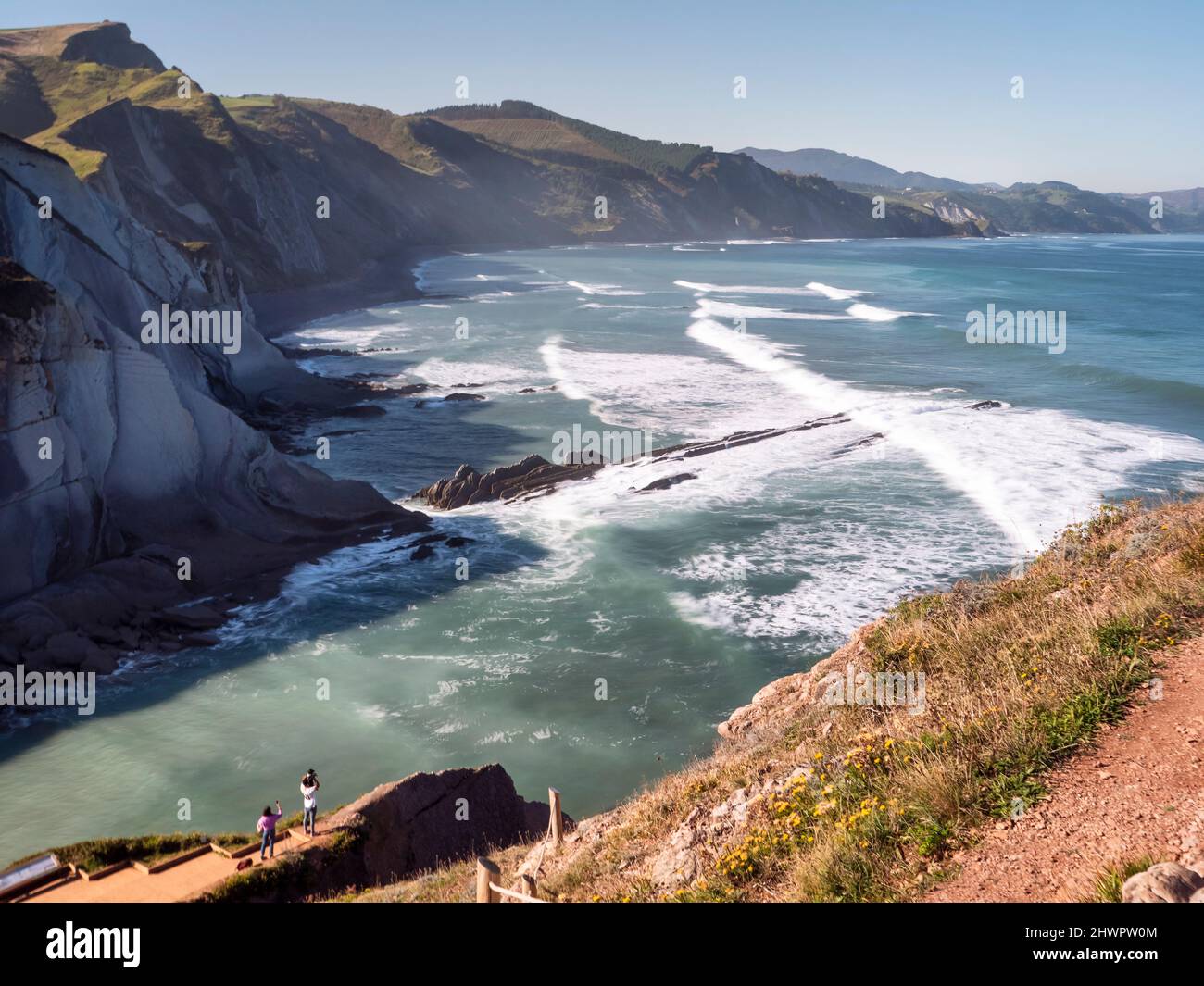 Onde di mare che precipitano verso la costa in giorno di sole, Basque Coast Geopark, Paesi Baschi, Spagna Foto Stock