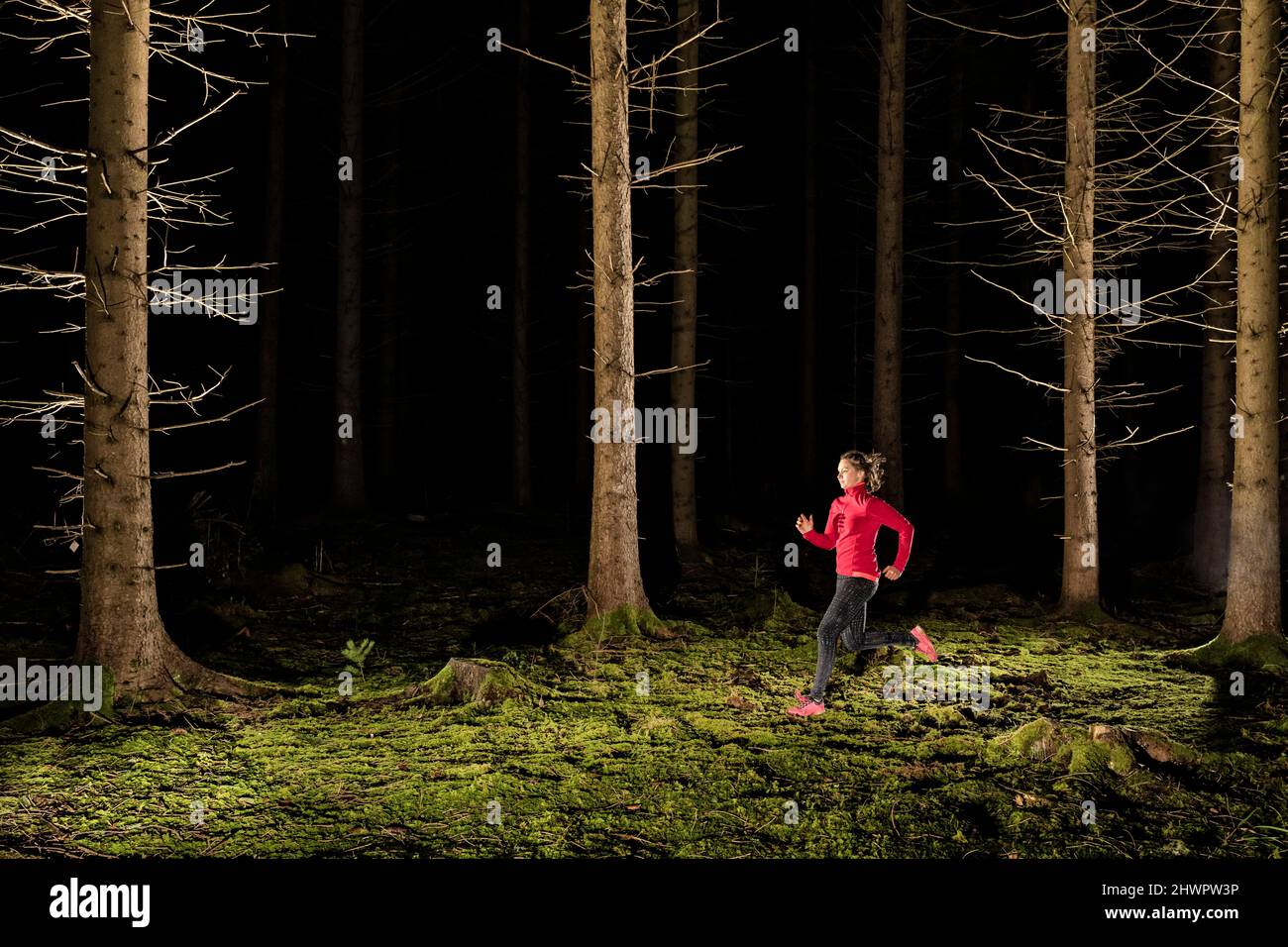 Donna che corre nella foresta scura Foto Stock