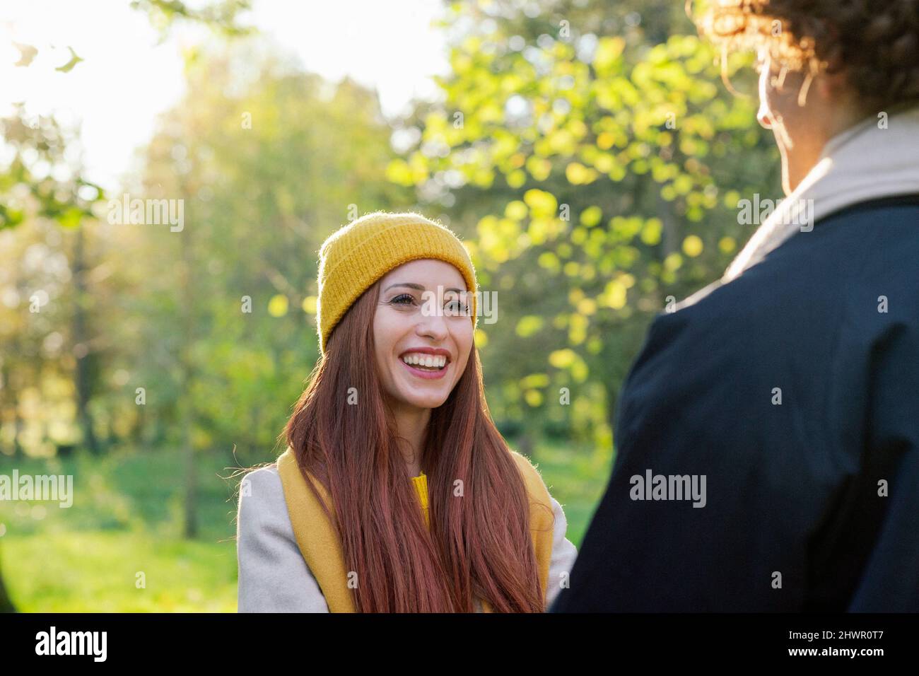 Sorridente donna rossa romanticing con ragazzo al parco Foto Stock