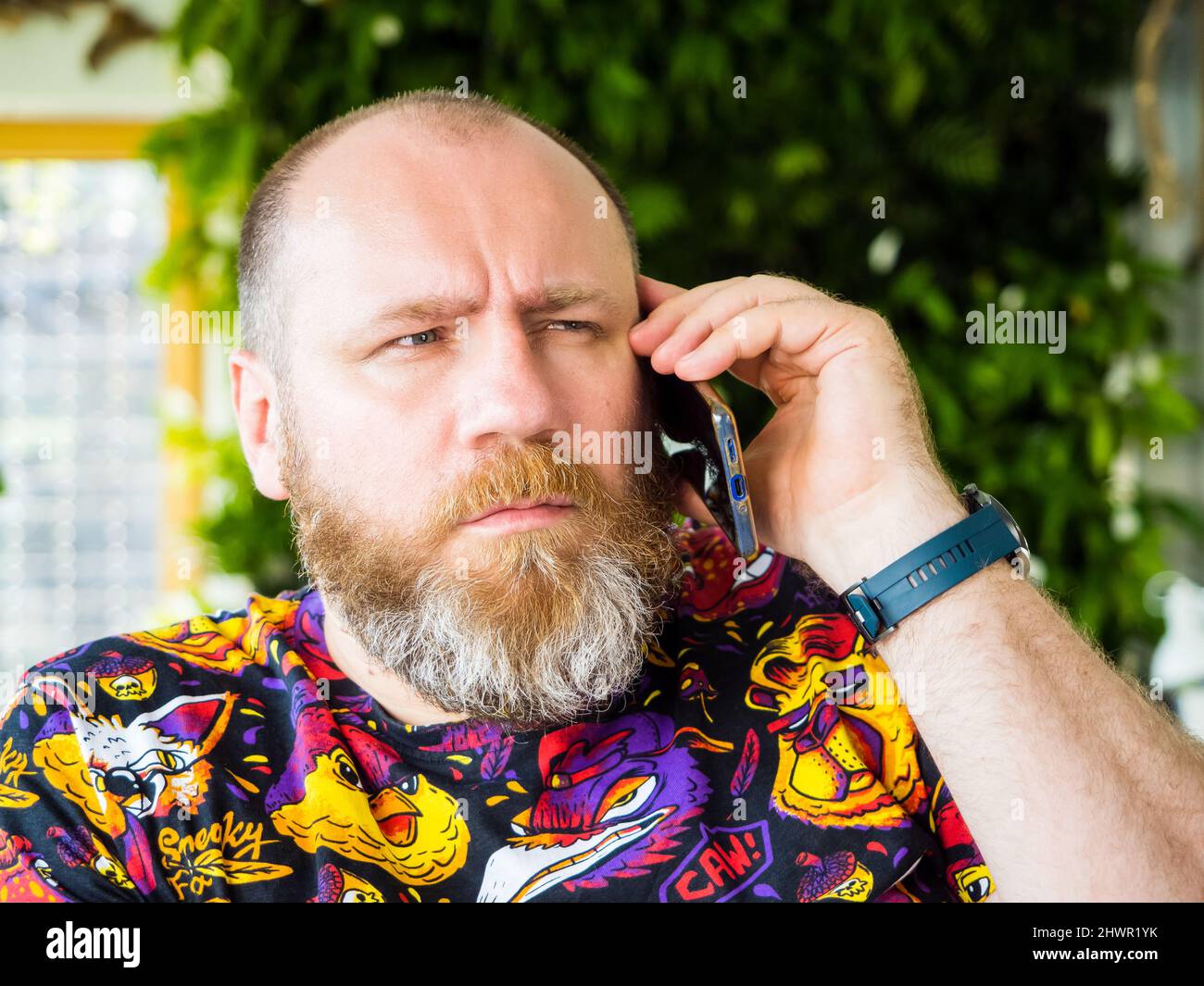 Candid foto di adulto preoccupato barbuto uomo parlare da smartphone Foto Stock