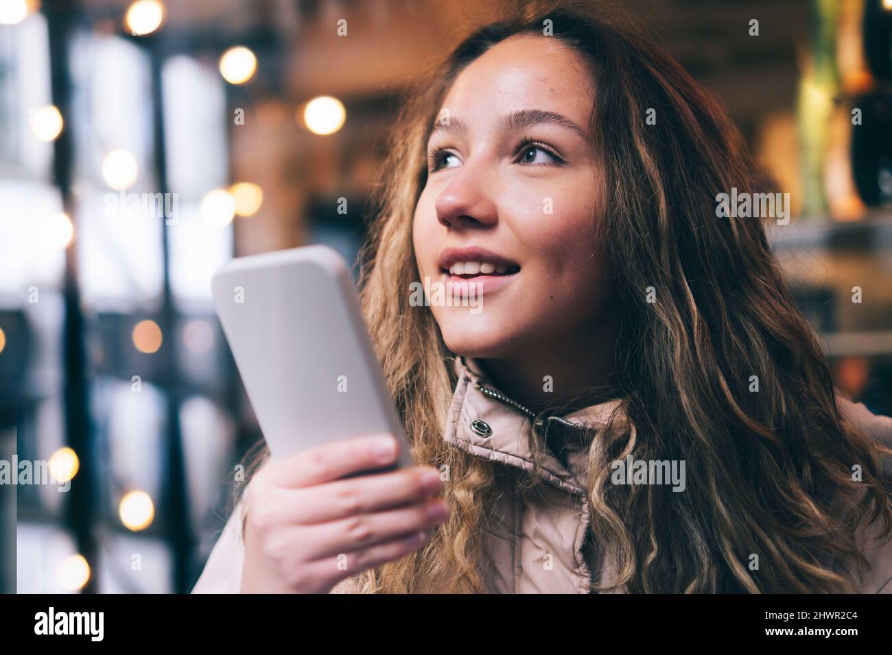 Giovane donna che invia messaggi vocali tramite smartphone Foto Stock
