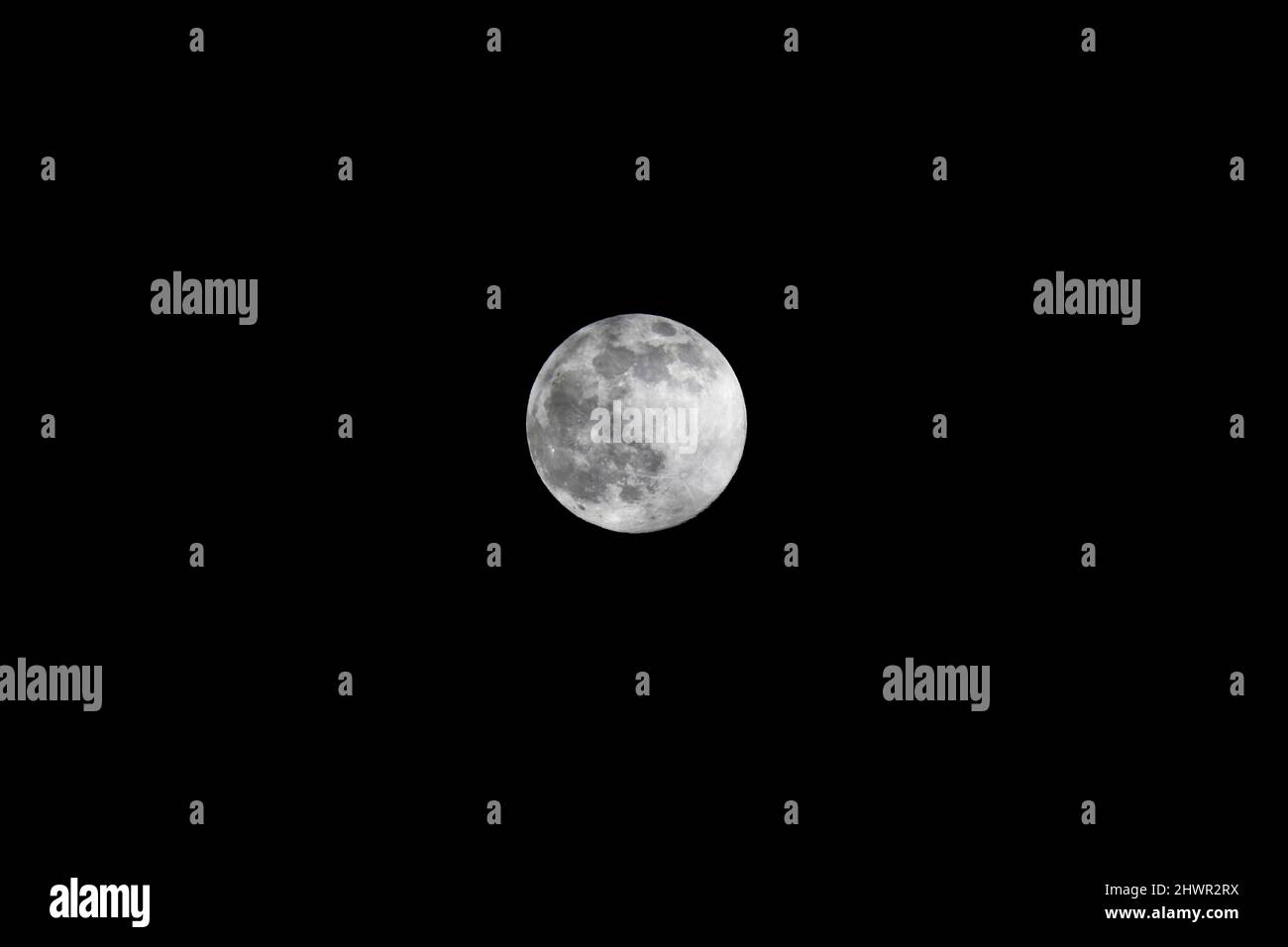 Luna piena che brilla di notte contro il cielo limpido Foto Stock
