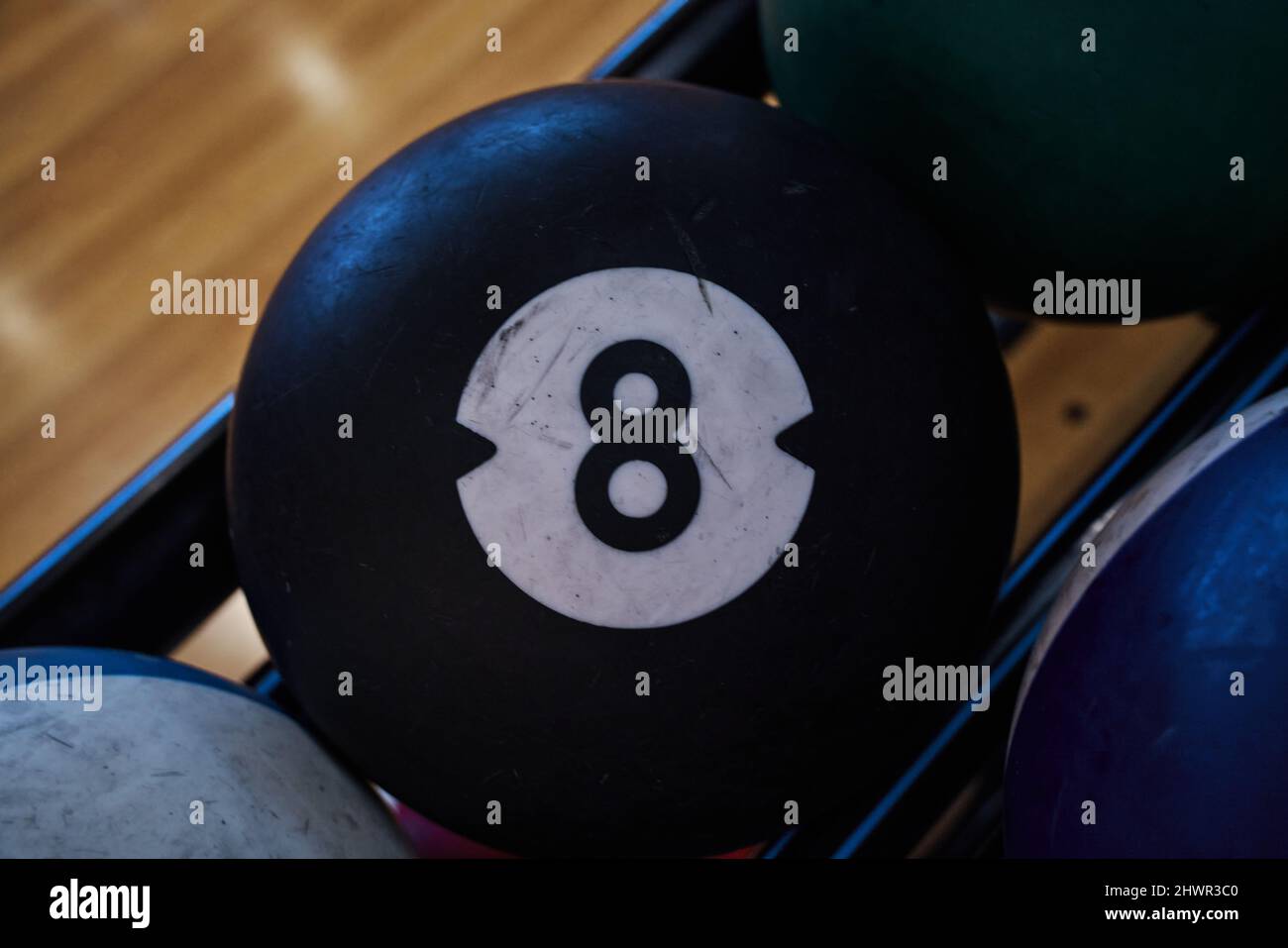 Usato palle di vari colori per giocare un gioco di bowling con fuoco nel numero nero 8. Foto Stock