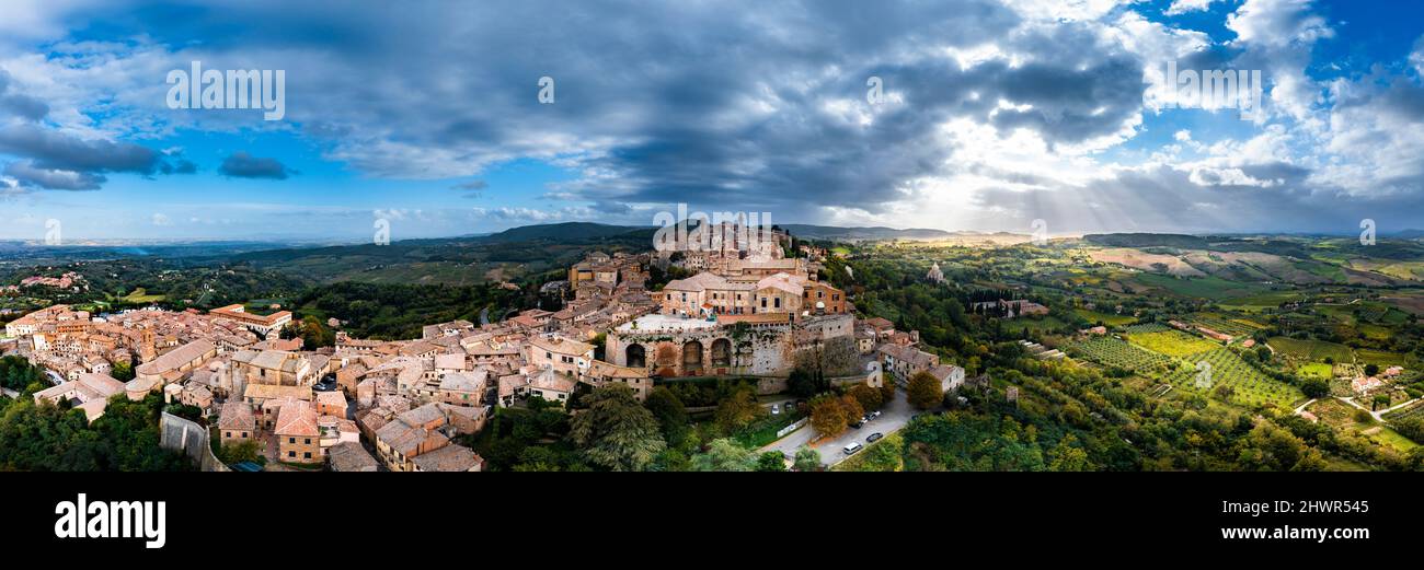 Italia, Provincia di Siena, Montepulciano, panorama in elicottero della città medievale collinare della Val d'Orcia al tramonto nuvoloso Foto Stock