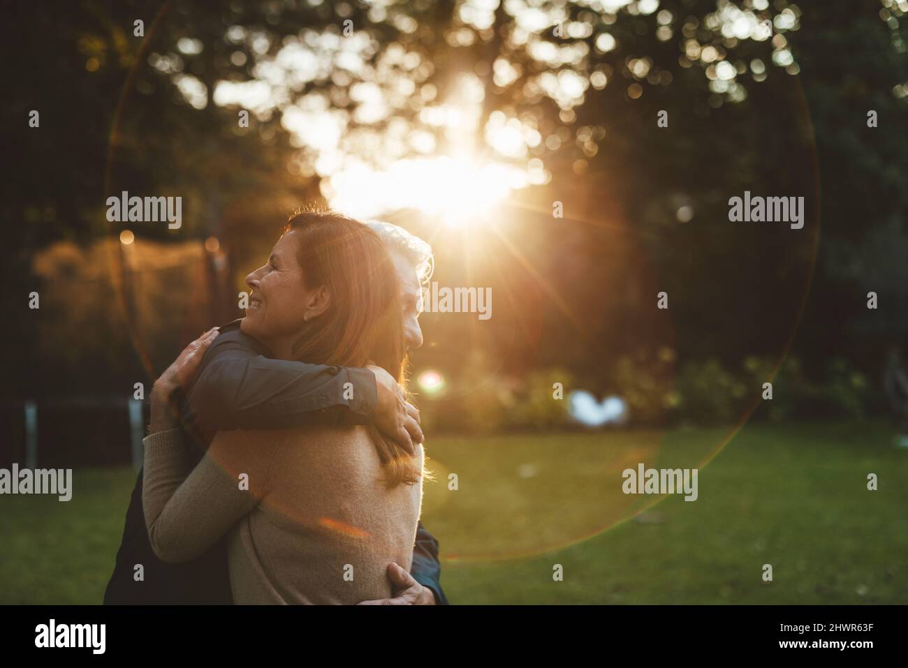 Coppia affettuosa abbraccia al tramonto sul cortile Foto Stock