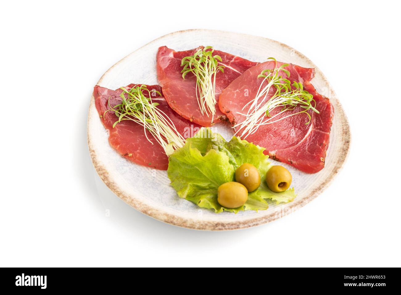 Fette di carne affumicata salata con coriandolo microfreen isolato su sfondo bianco. Vista laterale, primo piano. Foto Stock