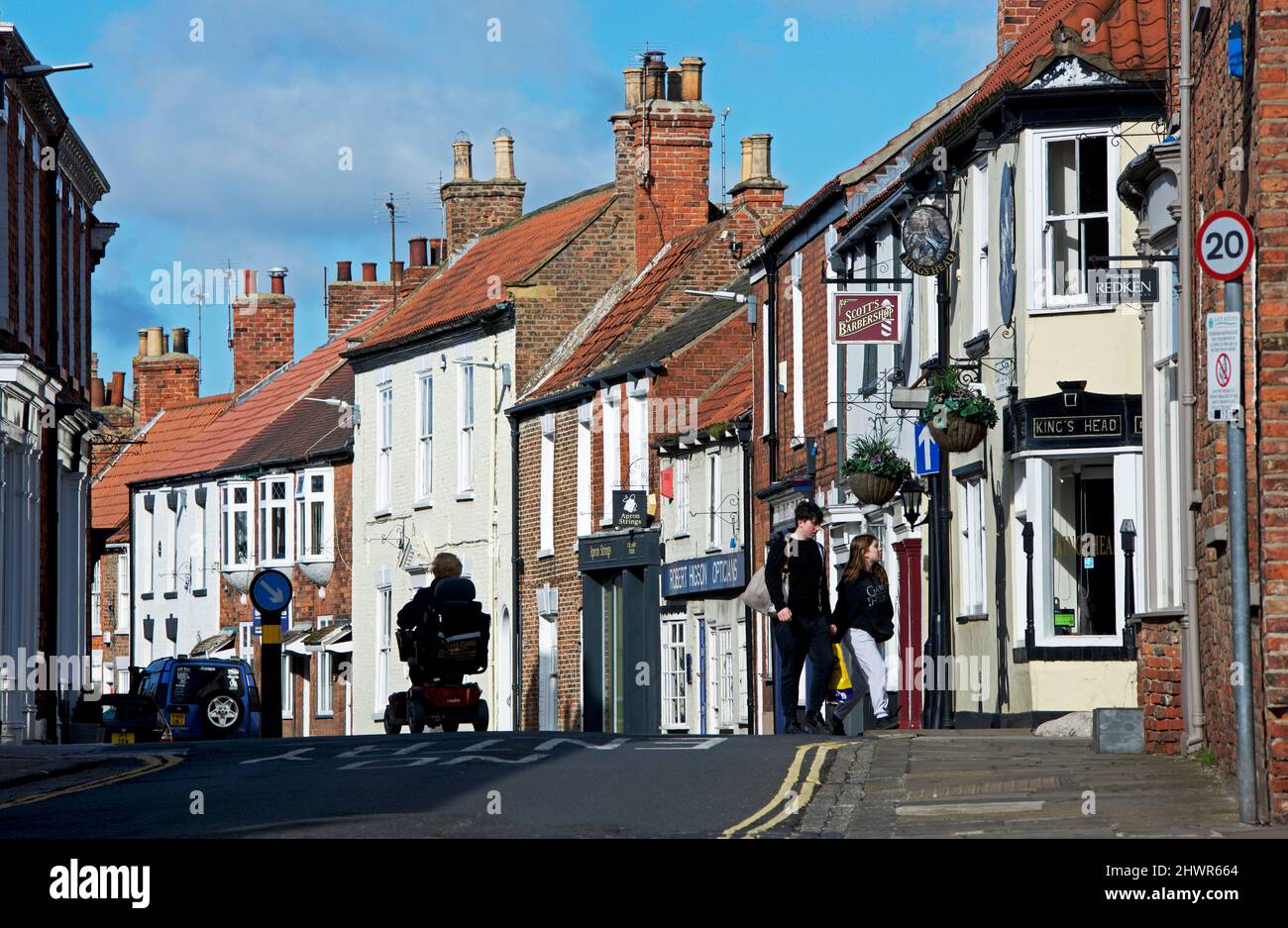 Donna su scooter per la mobilità. Souter Gate a Hedon, East Yorkshire, Inghilterra Regno Unito Foto Stock