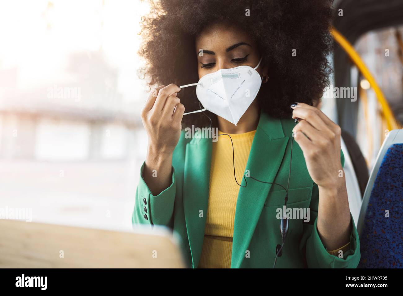 Pendolari indossare maschera protettiva viso e viaggiare in tram Foto Stock