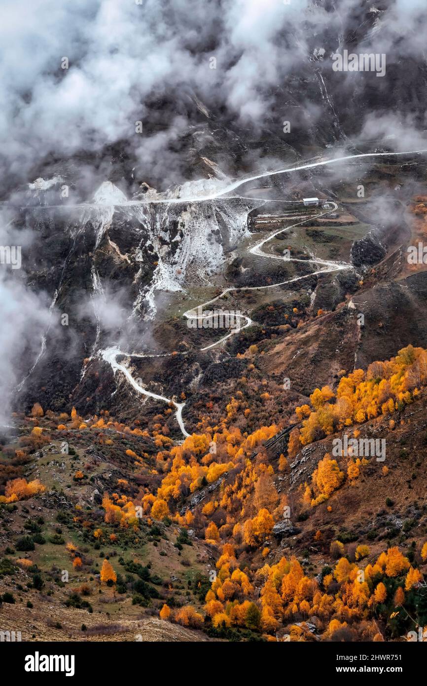 Strada che si snoda attraverso il paesaggio montagnoso del Caucaso settentrionale in autunno nebbia giorno Foto Stock